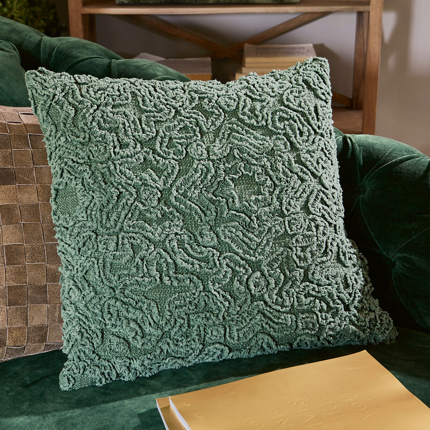 Groen decoratief kussen van zacht materiaal op groene bank, stijlvolle woonaccessoire