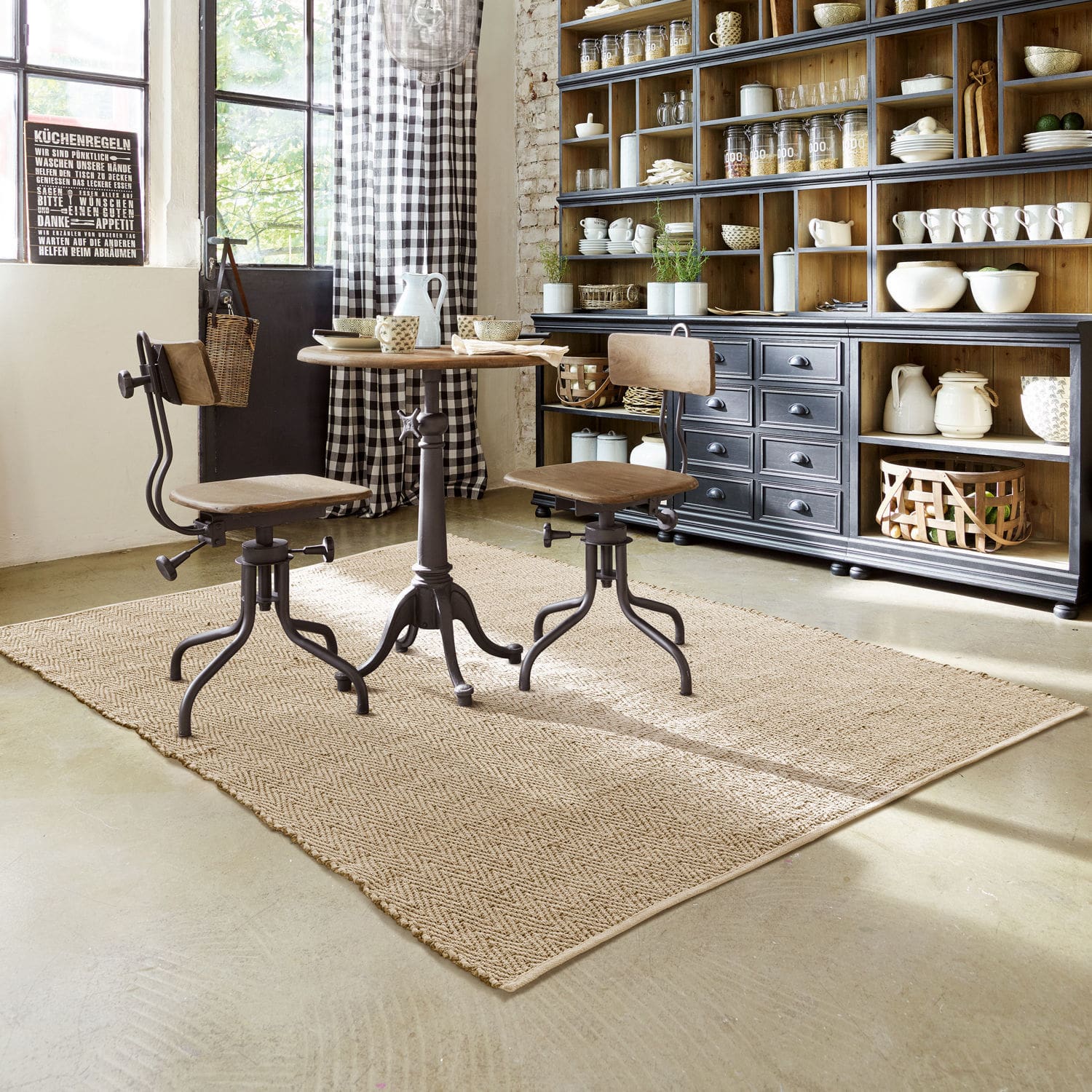 Vloerkleed Jonesboro Industriële tafel en stoelen van hout en metaal op beige vloerkleed in lichte keuken met kast