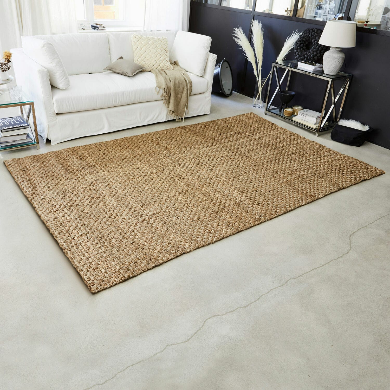 Vloerkleed Daoukro Beige jute vloerkleed op lichte vloer in moderne woonkamer met witte bank
