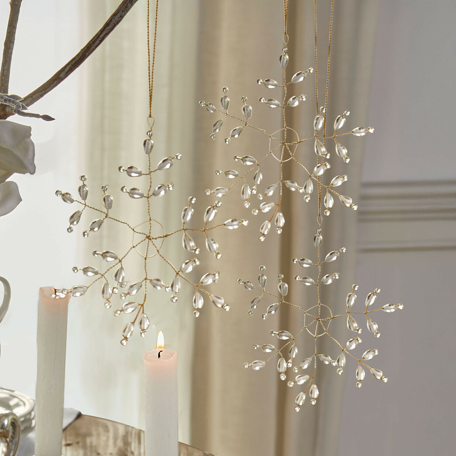 Decoratieve sneeuwvlokhangers van transparante kralen aan gouden draad voor kerstdecoratie