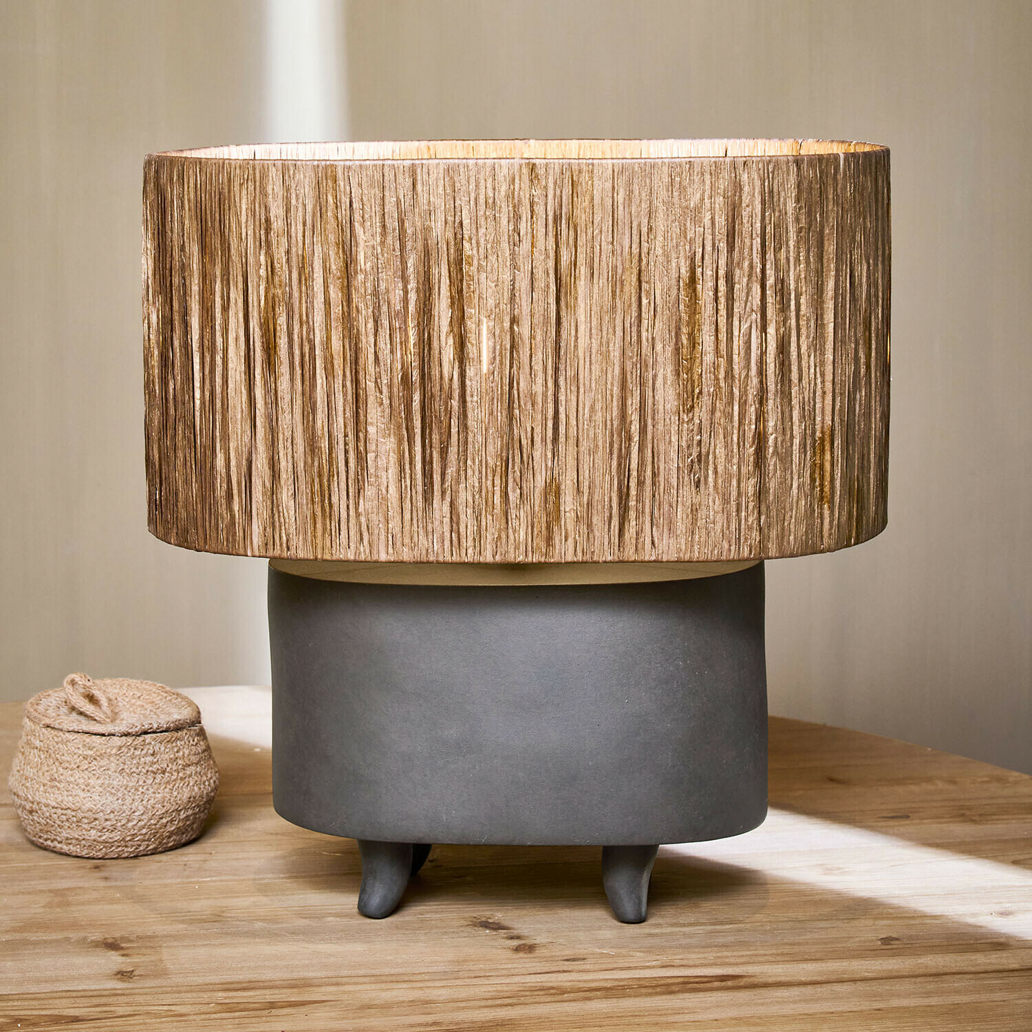 Tafellamp met grijze keramische voet en beige kap van natuurlijk materiaal, interieurdecoratie