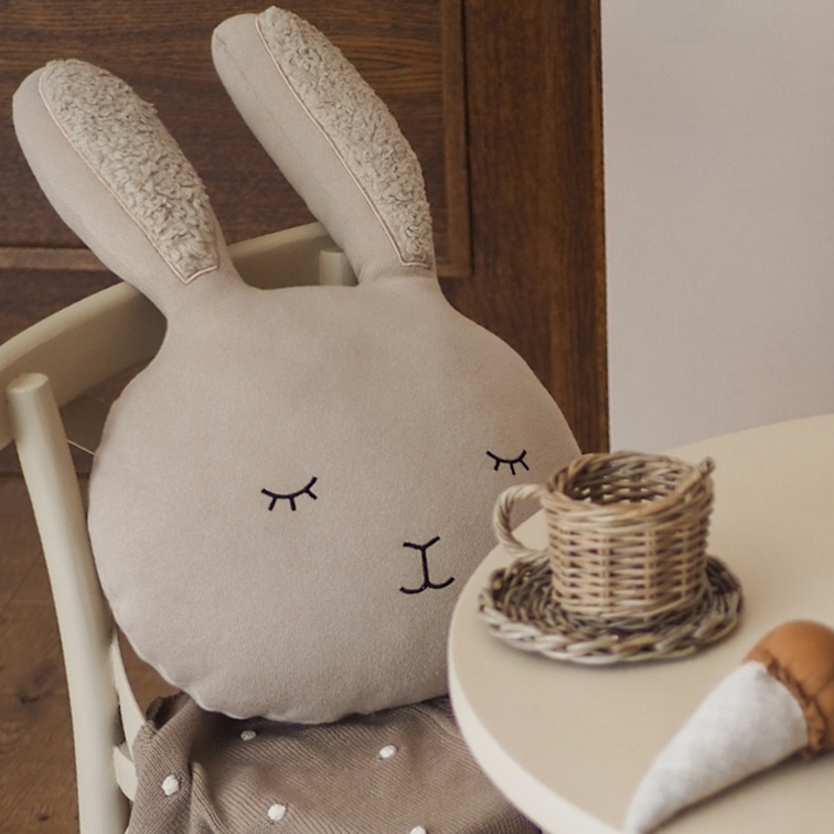 Beige konijnenkussen van zacht materiaal met geborduurde oren en gezicht, geschikt voor kinderkamer