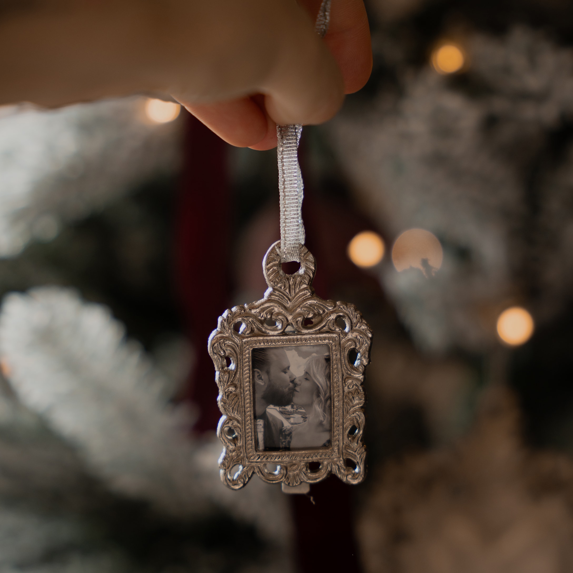 Kerstversiering zilveren fotolijst met zwart-wit foto van kussend paar