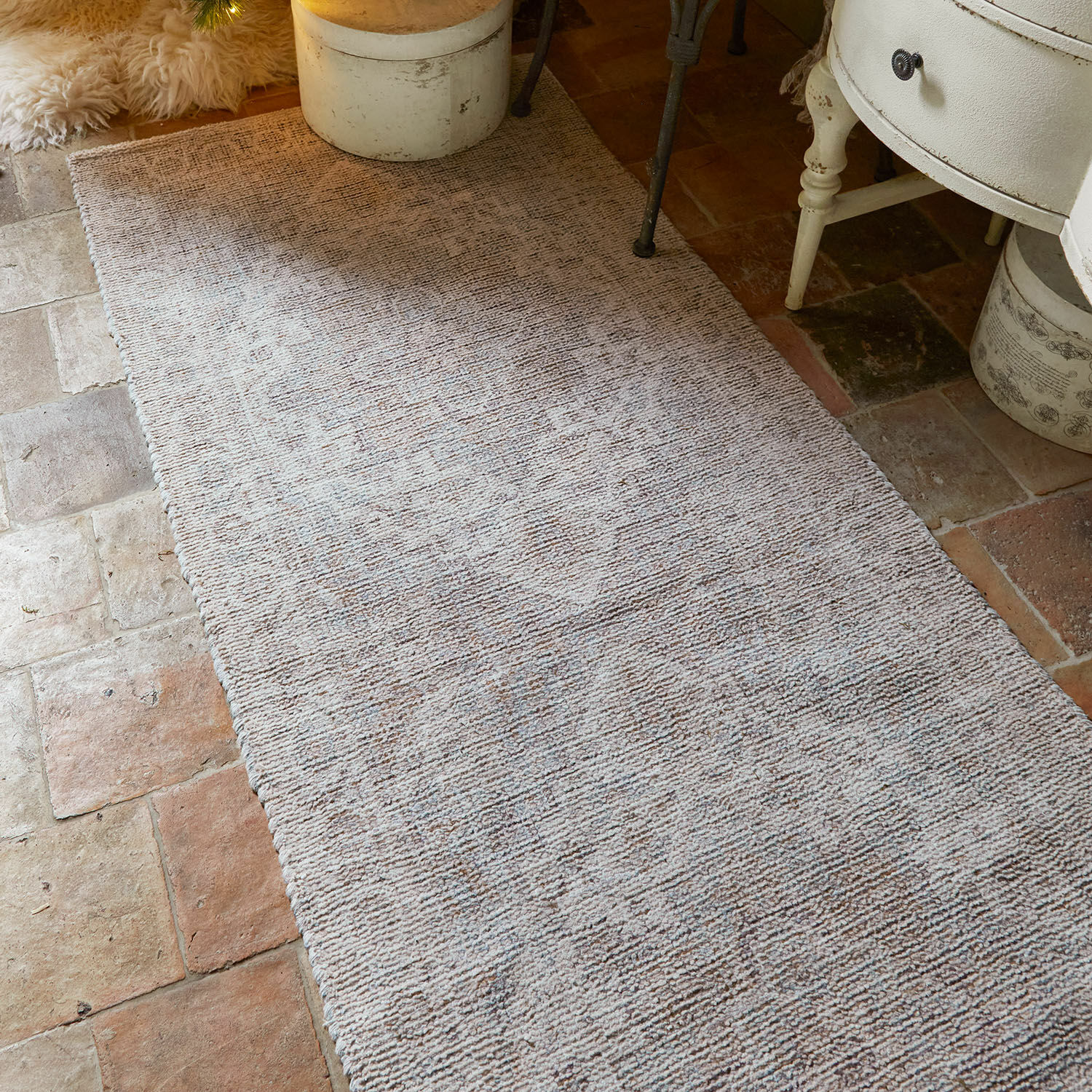 Beige vloerkleed met subtiel patroon op stenen vloer, interieurdecoratie en comfort