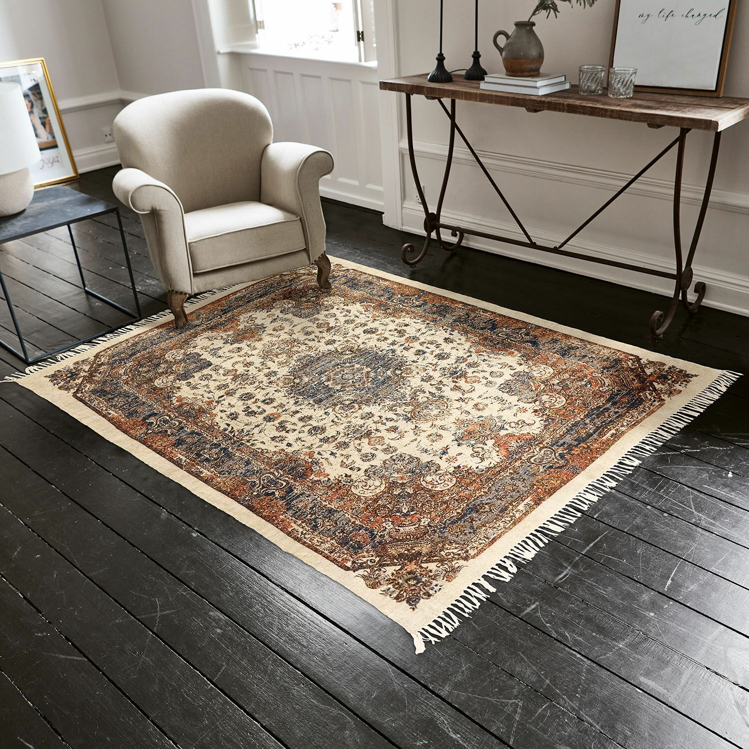 Vloerkleed Aleixo Oosterse vloerkleed in crème, blauw en bruin op donkere houten vloer in woonkamer