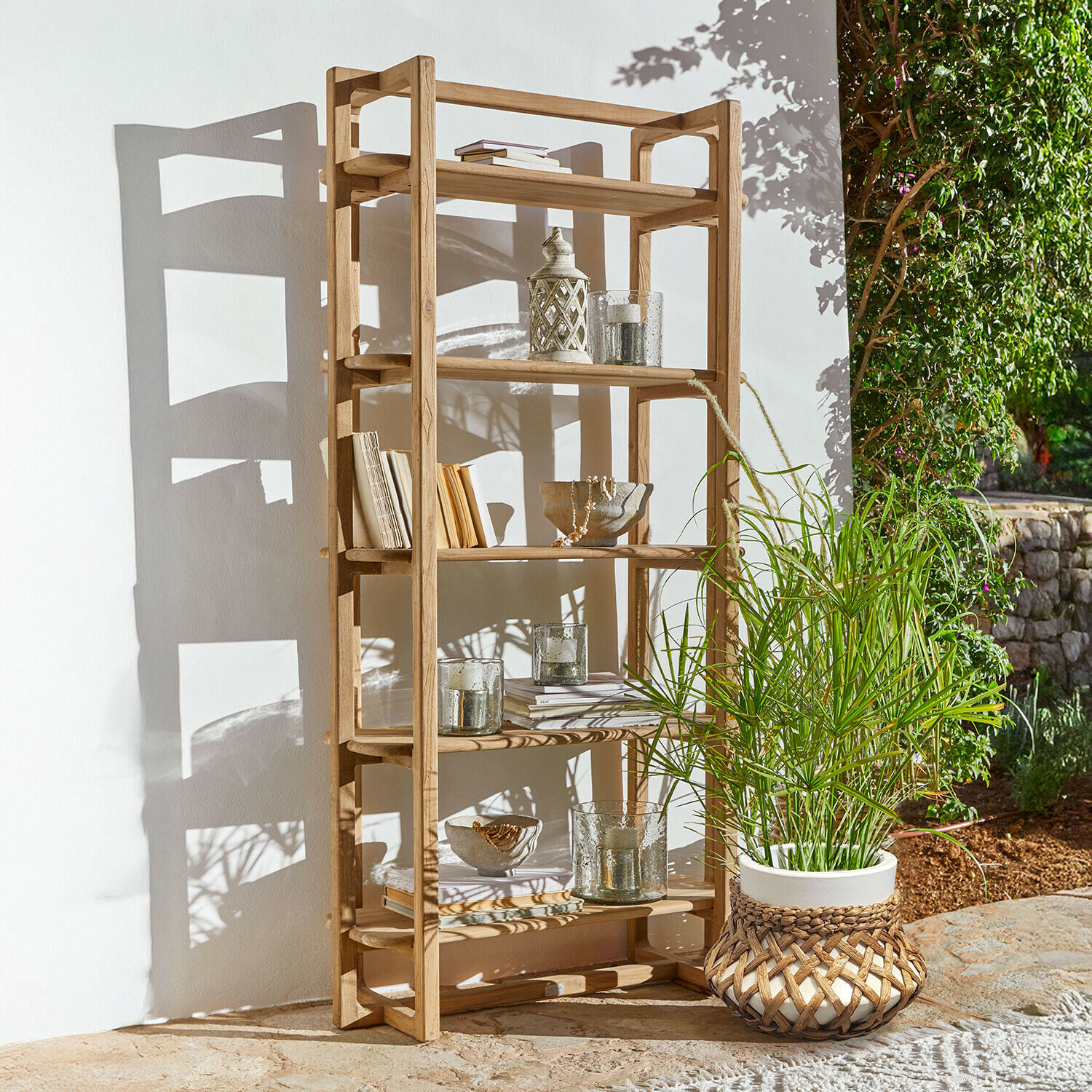 Houten kast van natuurlijk hout met decoraties en potplant buiten in de zon