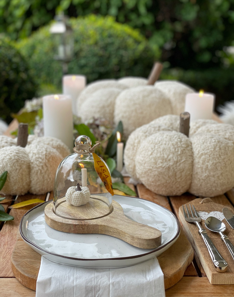 Herfsttafel met witte, zachte pompoendecoraties en kaarsen op een houten tafel