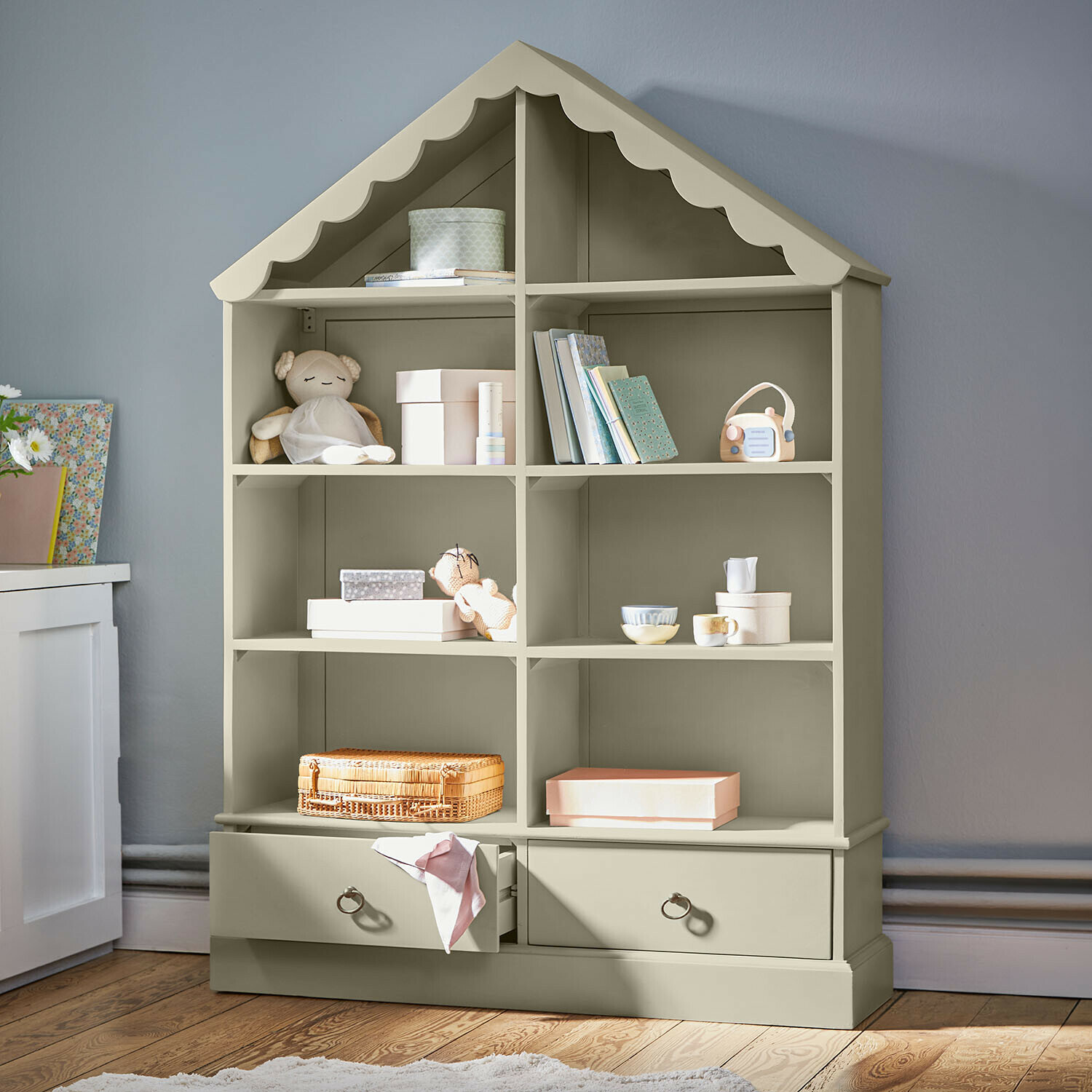 Grijze houten kast in huisvorm met speelgoed en boeken, meubel voor kinderkamer
