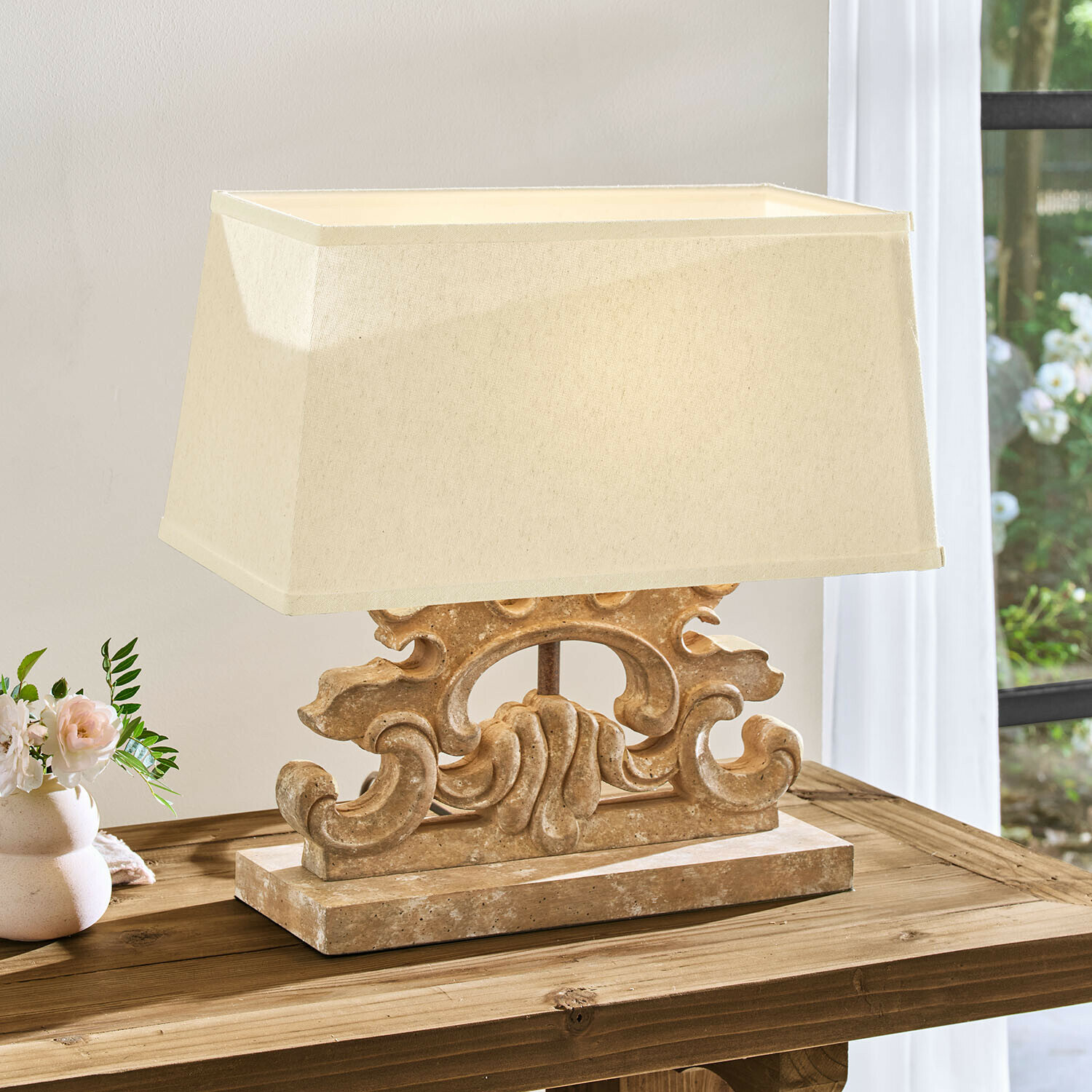 Tafellamp met beige kap en decoratieve stenen voet in vintage stijl