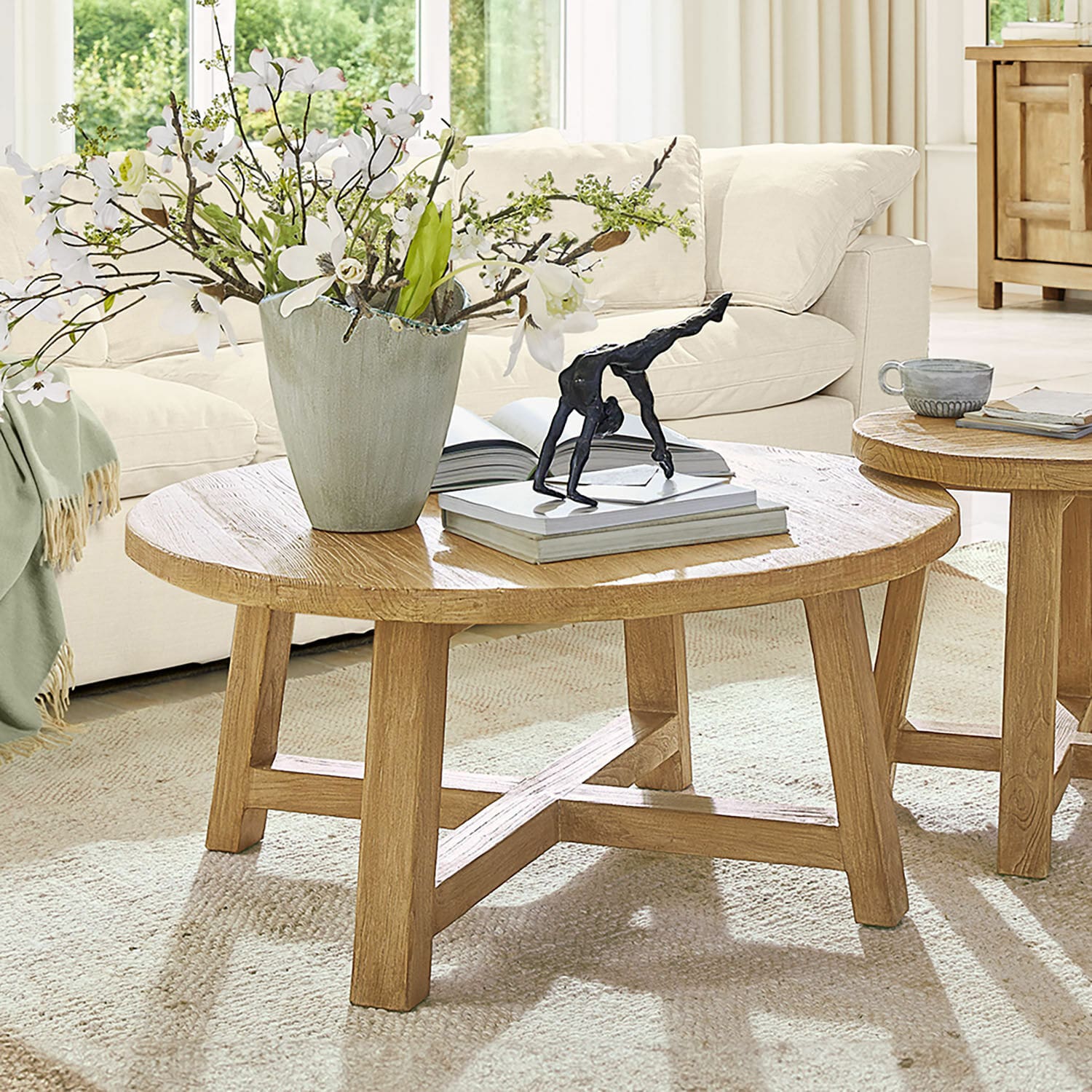 Salontafel Gorivel Ronde salontafel van natuurlijk eikenhout met decoratie en boeken in lichte woonkamer