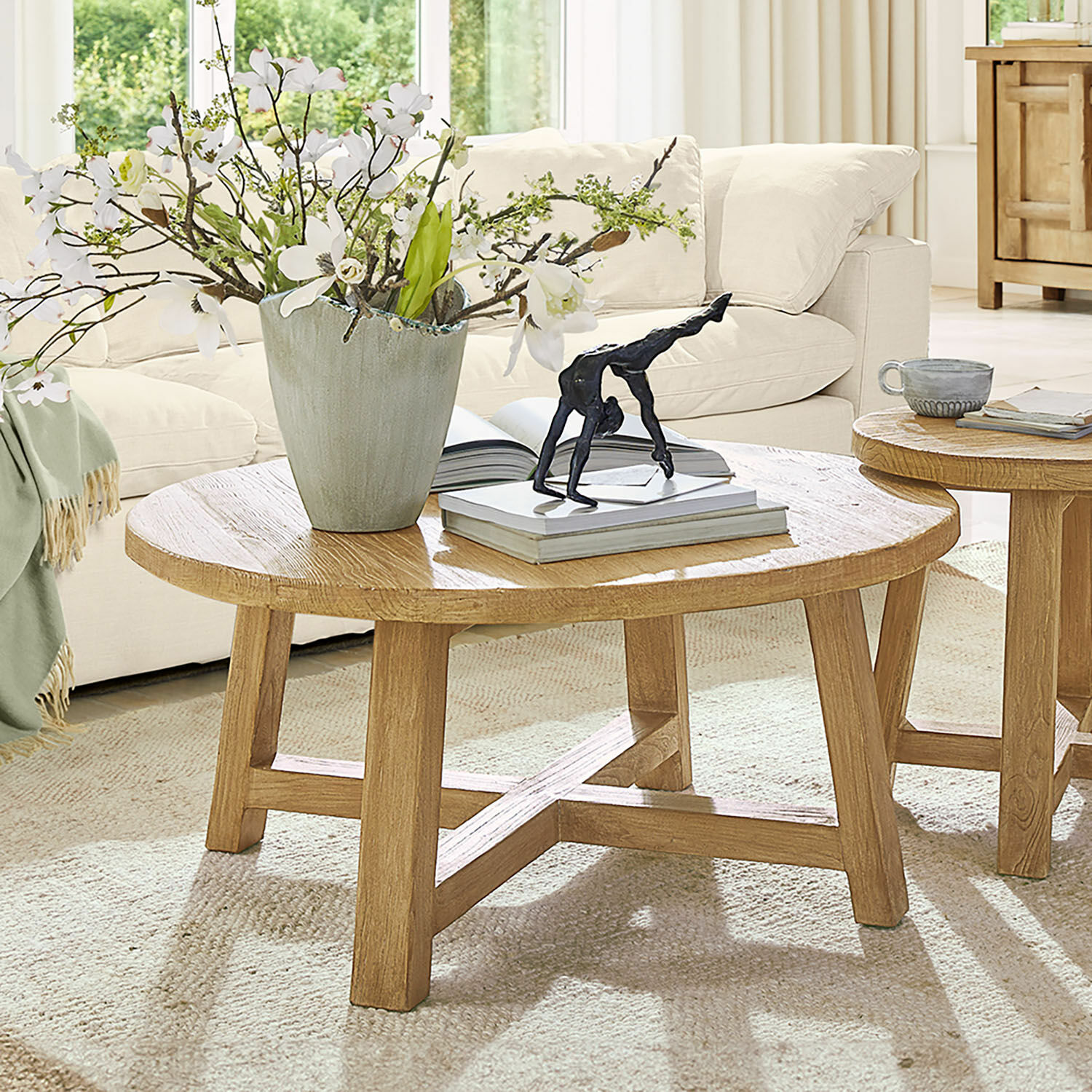 Salontafel Gorivel Ronde salontafel van natuurlijk eikenhout met decoratie en boeken in lichte woonkamer