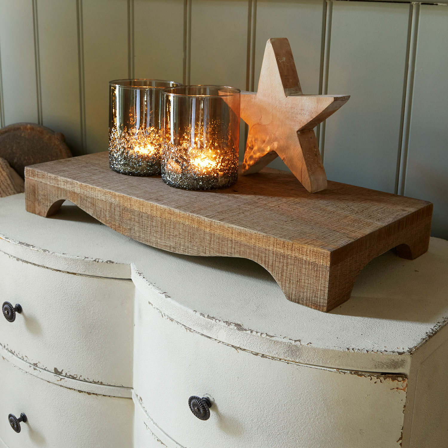 Dienblad Torviano Houten dienblad met twee glazen theelichthouders en houten ster op witte shabby chic ladekast