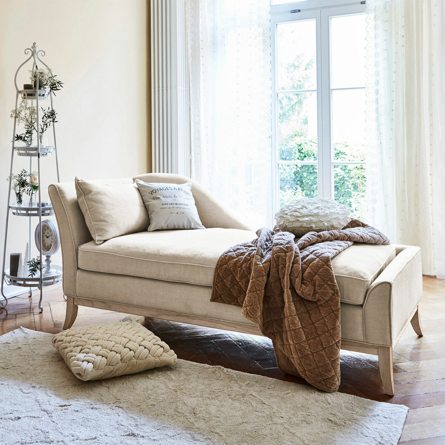 Chaise longue Alphonse Beige stoffen chaise longue met kussens en bruine deken in lichte woonkamer