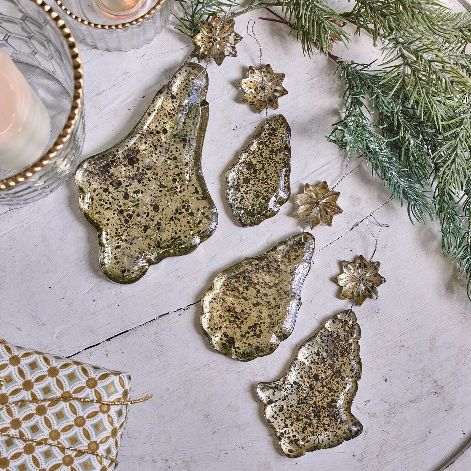 Set gouden metalen kerstversieringen in de vorm van bellen en sterren op witte achtergrond