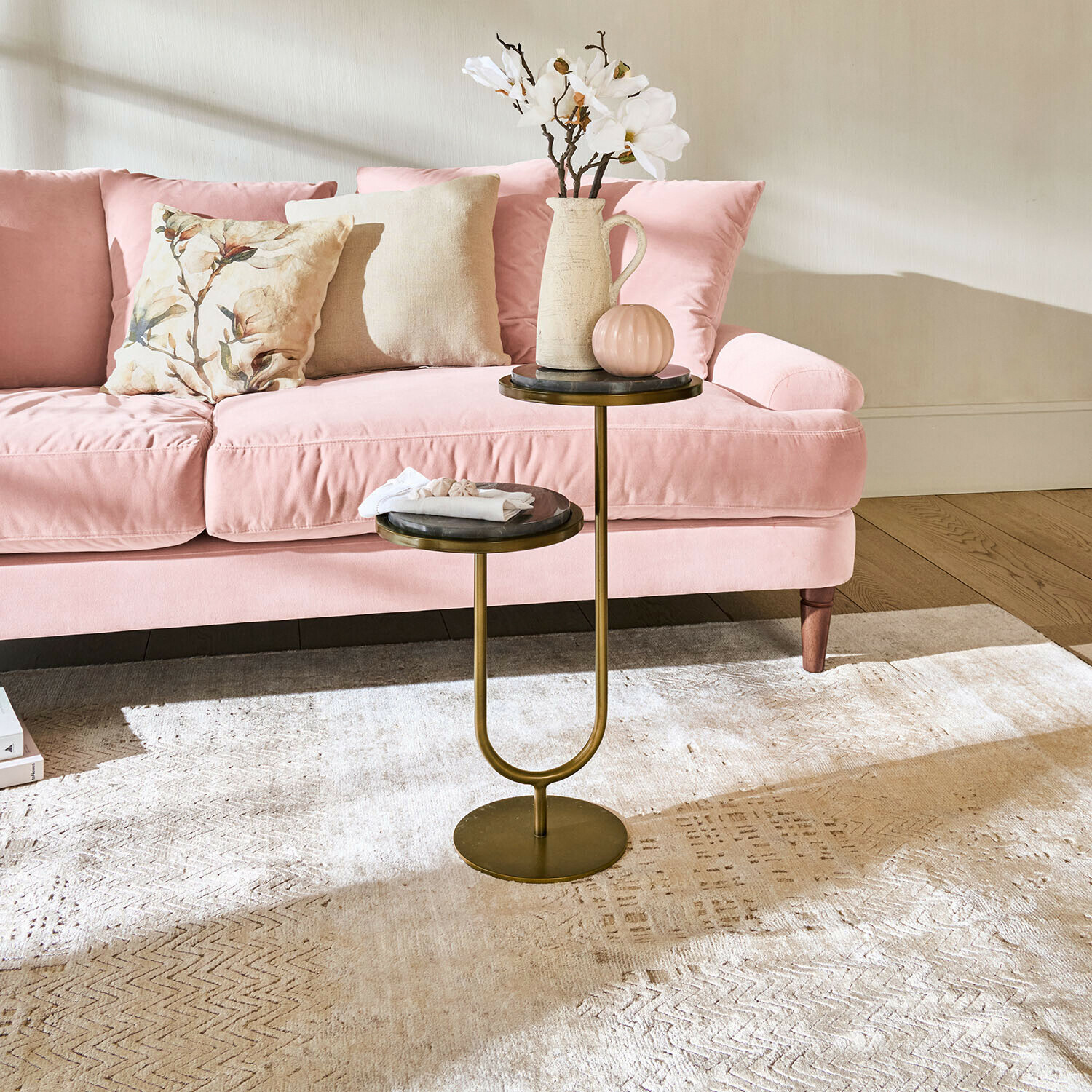 Dubbele bijzettafel met metalen frame en marmeren bladen voor een roze bank in de woonkamer