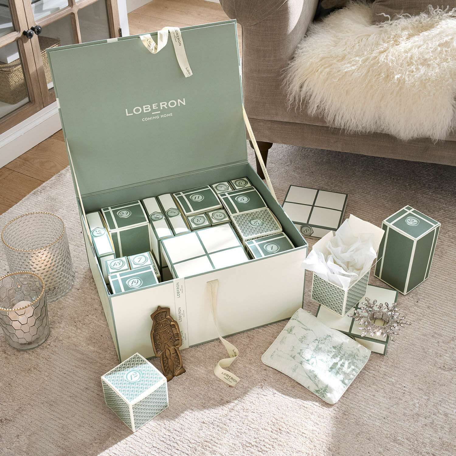 Adventskalender Calavira Groen-witte adventskalender dozen op beige tapijt naast bank met bontdeken