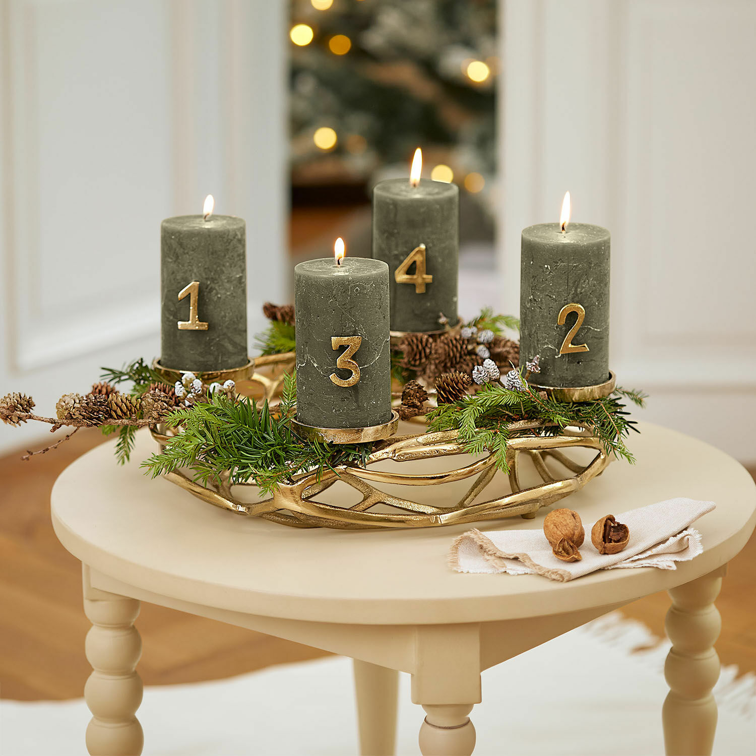 Kaarsenkrans Coldfield Groene adventskrans met vier kaarsen en gouden cijfers op een beige tafel