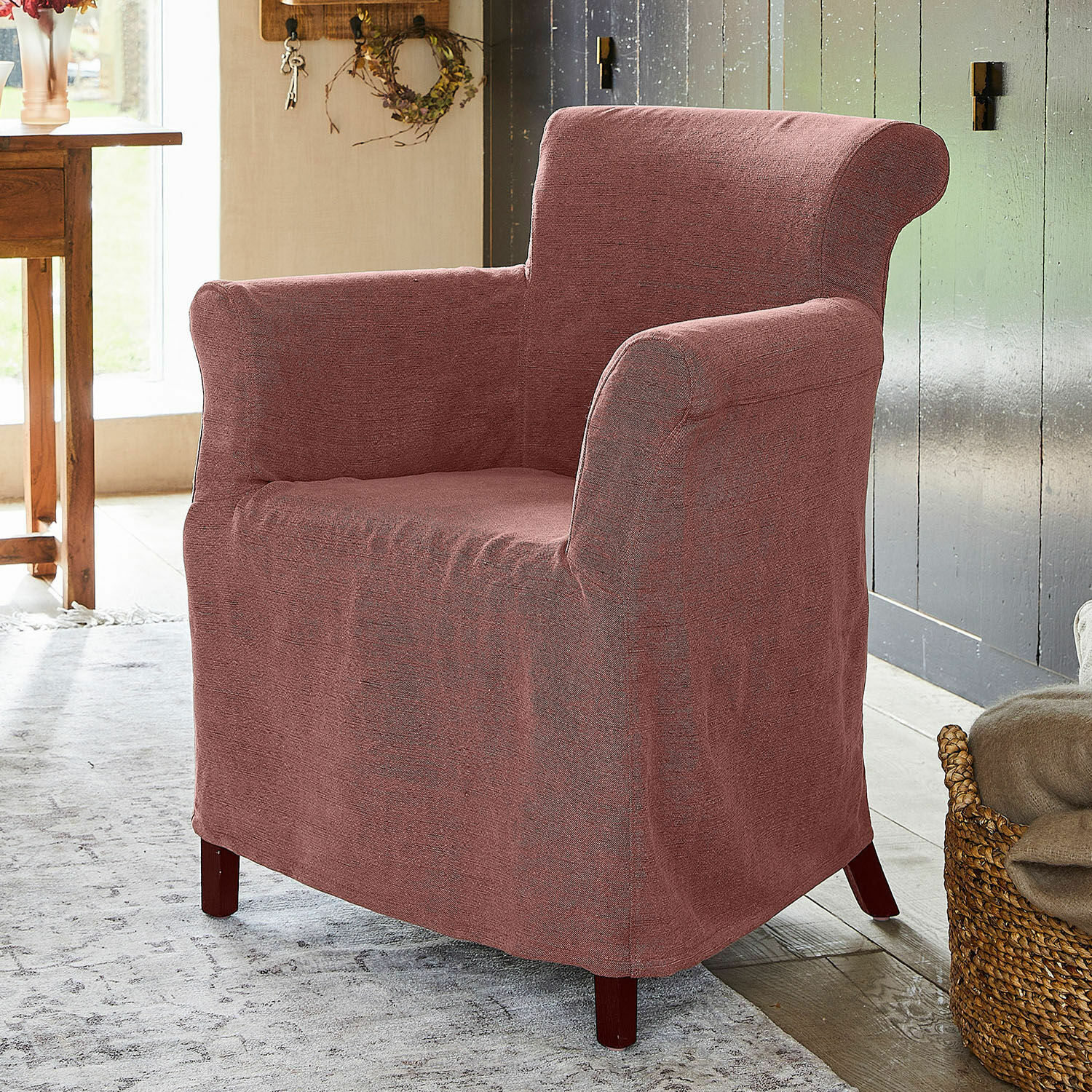 Roze stoffen fauteuil met hoge rugleuning en houten poten in een gezellige kamer