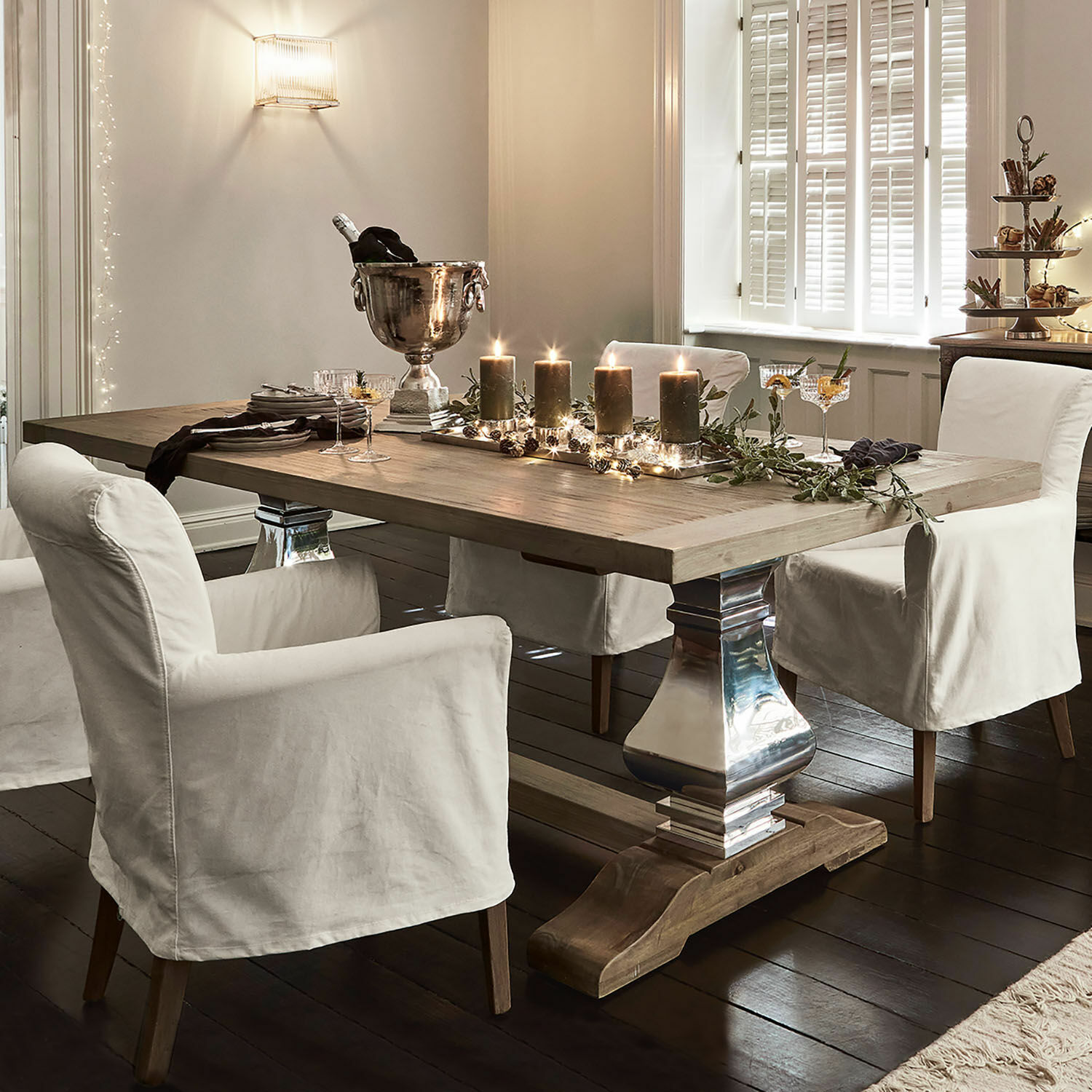 Eettafel Filton Lichte houten eettafel met metalen poten en witte stoelhoezen in een elegante kamer