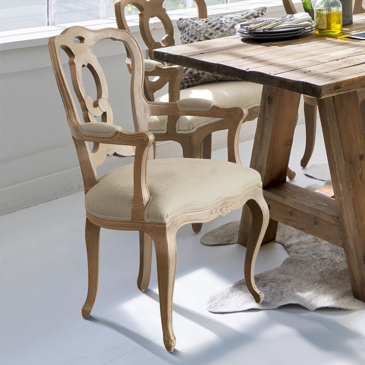 Klassieke houten stoel met beige bekleding bij houten tafel in lichte kamer