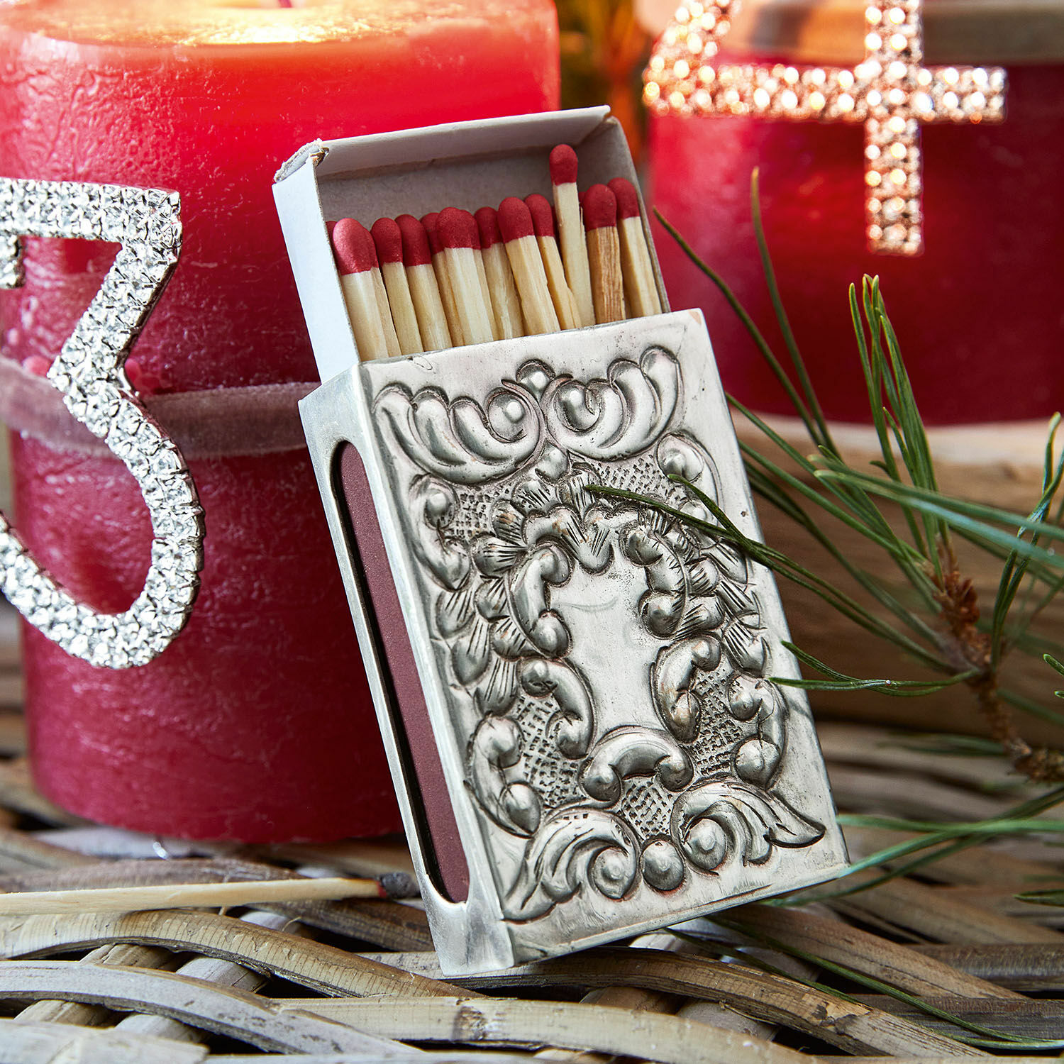 Etui voor luciferdoosje Lytham Decoratief metalen luciferdoosje met rode koppen en rode kaarsen op de achtergrond