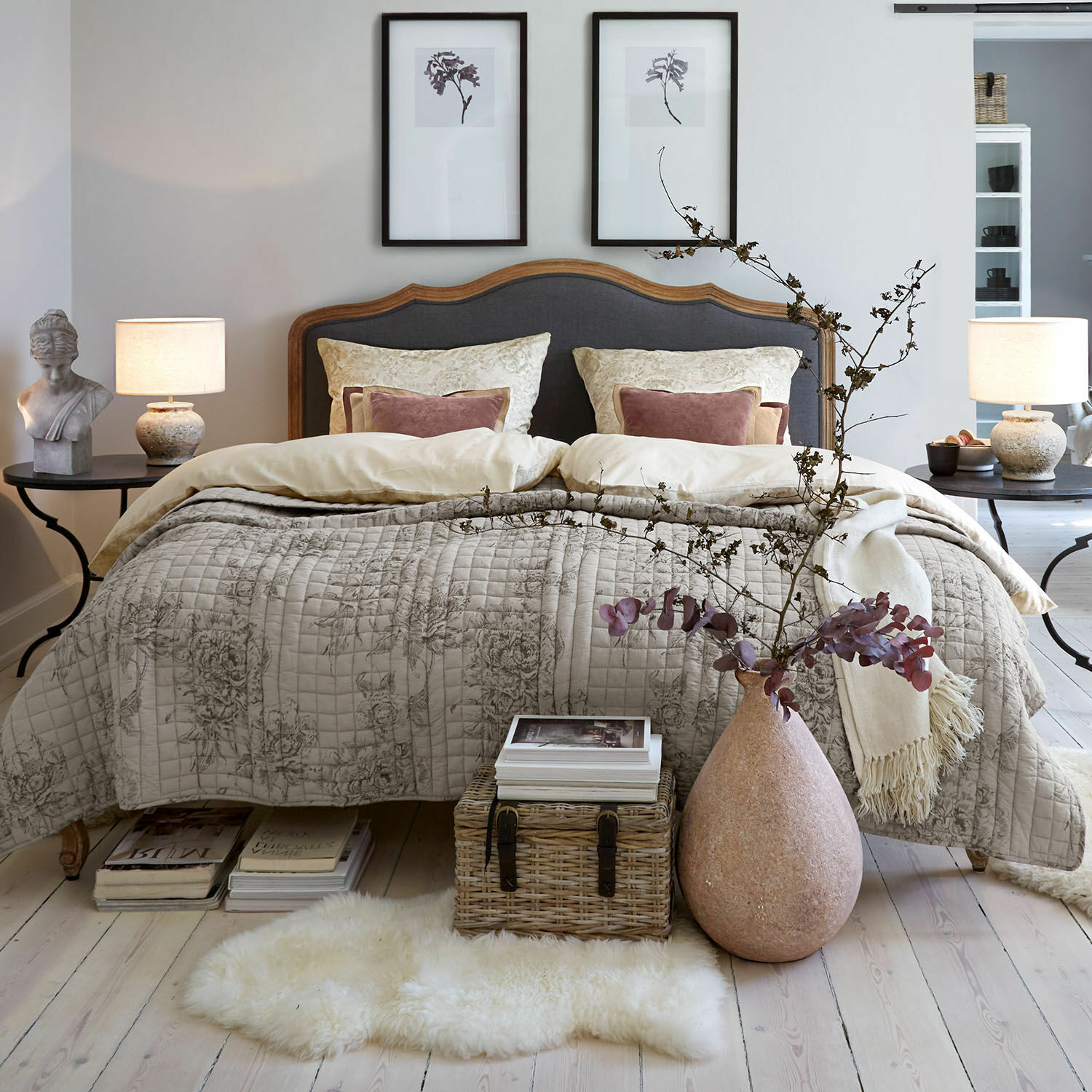 Bed Serravalle Gezellige slaapkamer met houten bed en beige gewatteerd dekbed met bloemenpatroon