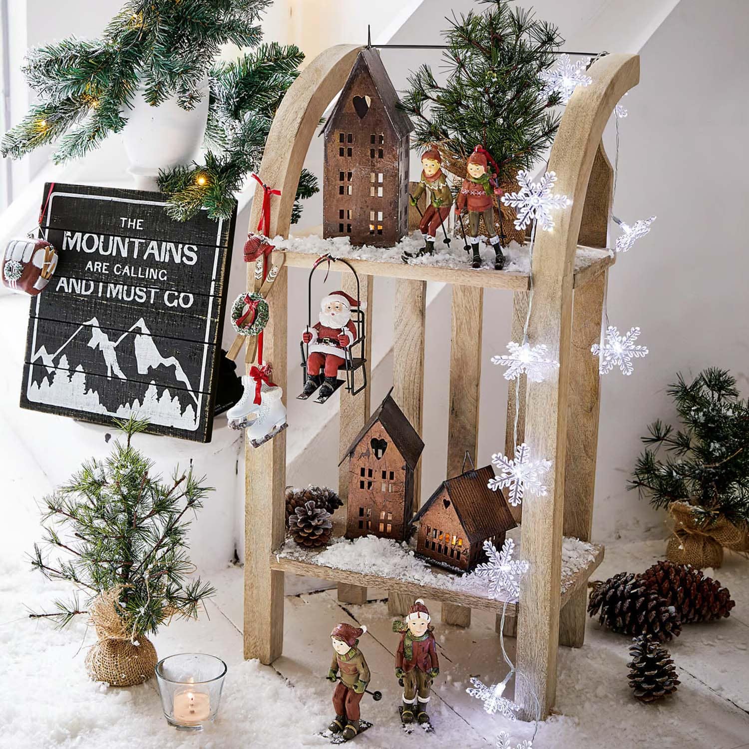 Houten kerstdecoratie met skiërs, kerstman en huisjes op kunstsneeuw