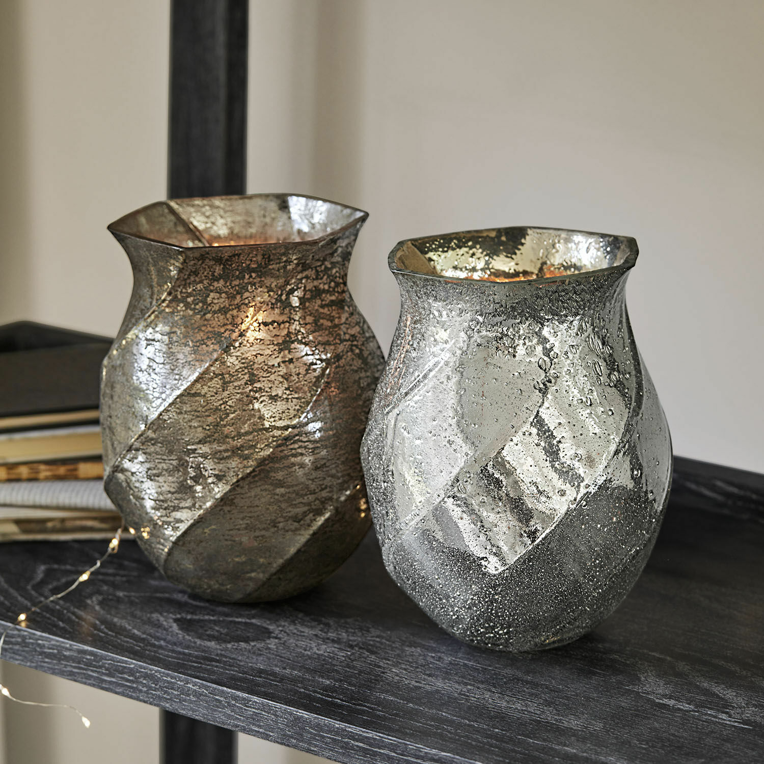 Windlicht set van 2 Tixovel Twee decoratieve glazen vazen in zilver en goud met textuur op een donkere plank