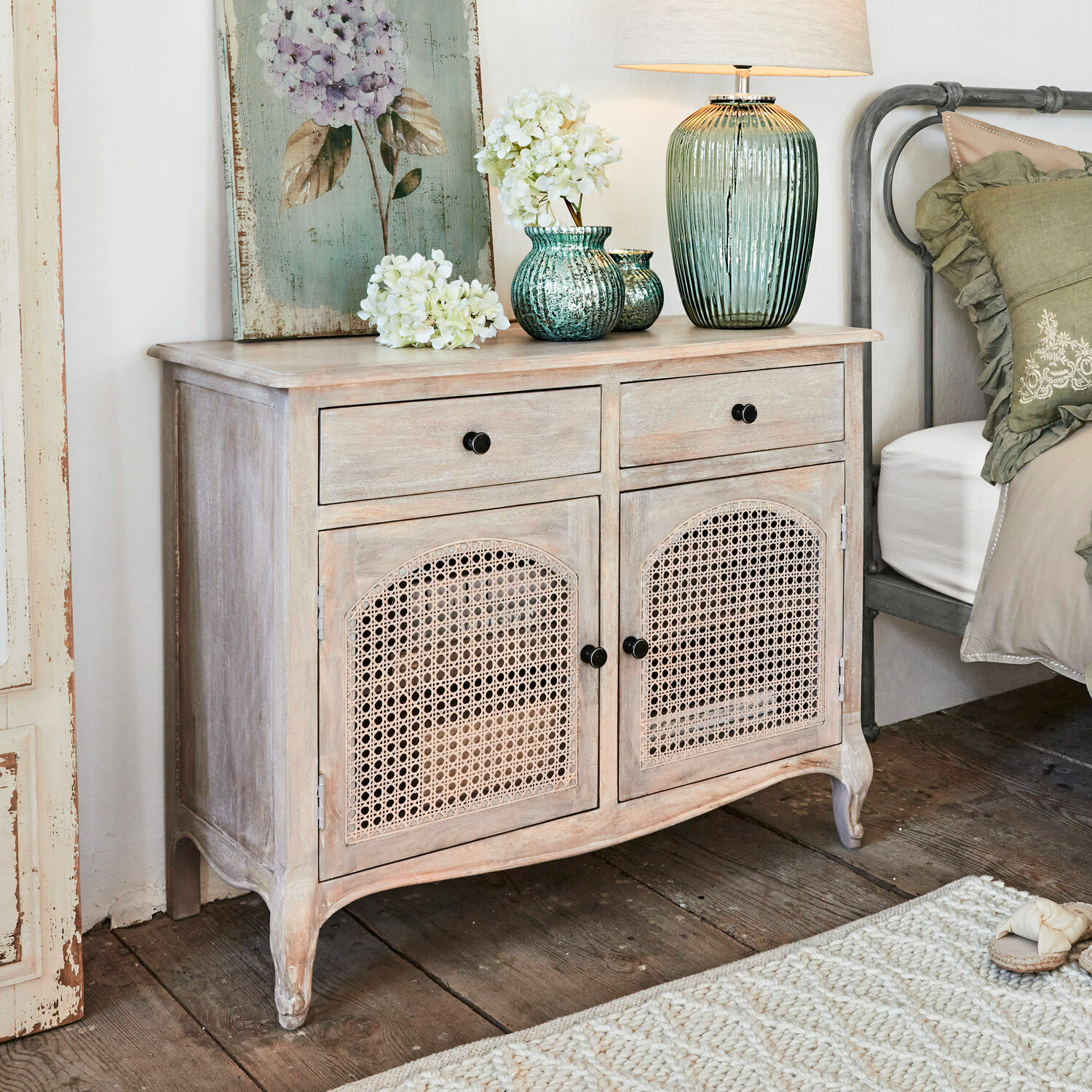 Lage kast Truso Lichte houten kast met gevlochten deuren, decoraties en lamp erop