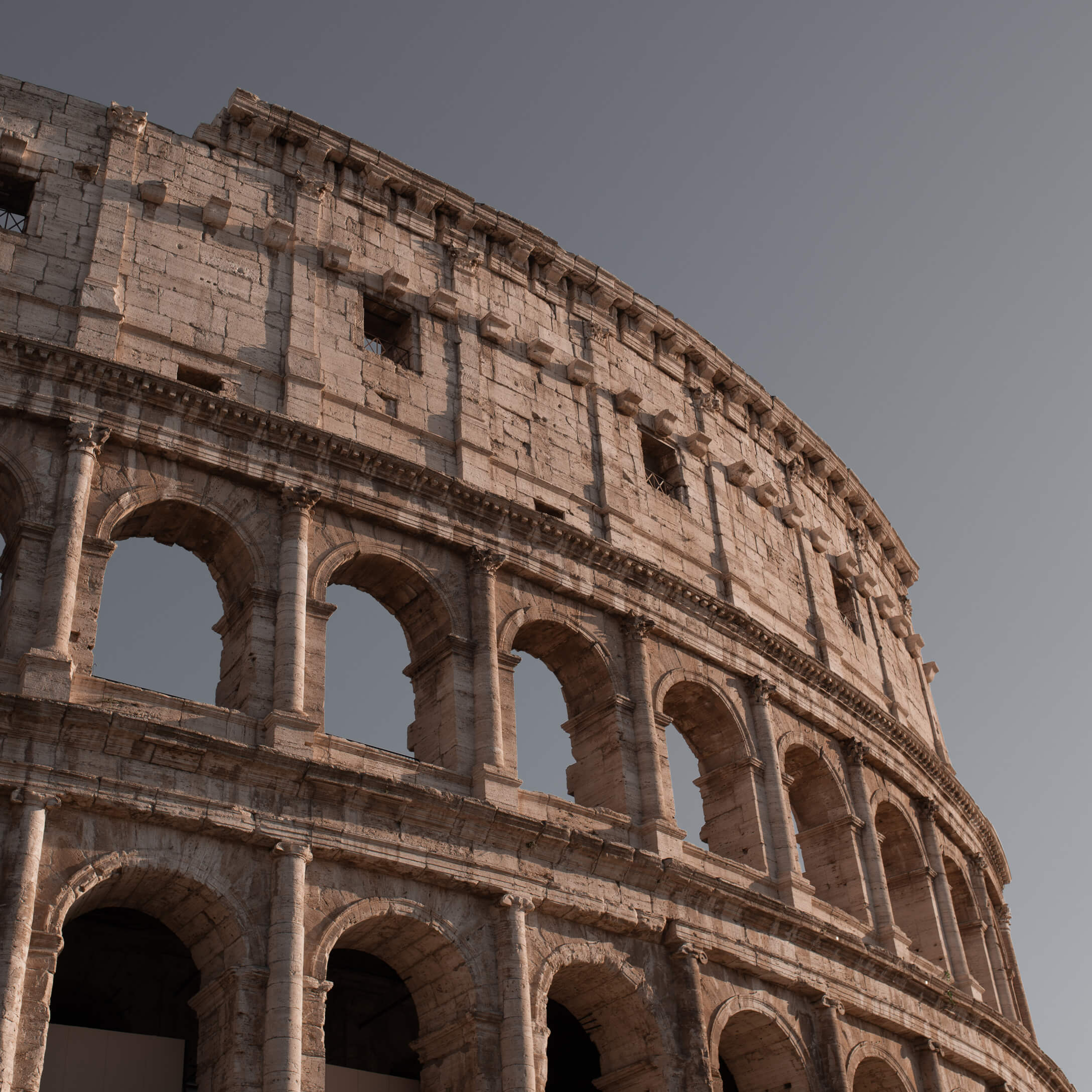 Detail van het oude Romeinse Colosseum van warme steen onder een heldere blauwe lucht