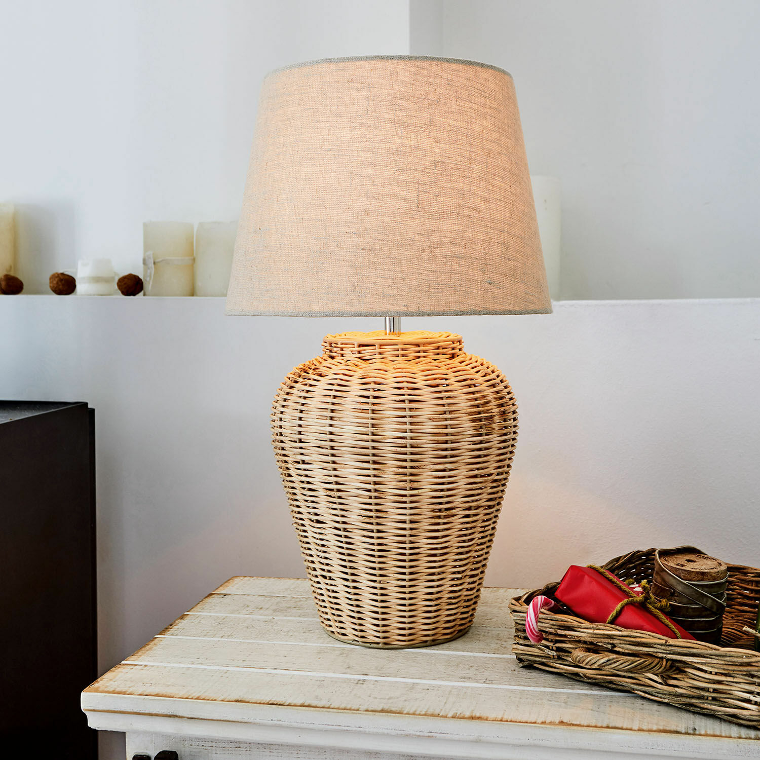 Tafellamp van gevlochten riet met beige kap op houten tafel, interieurdecoratie