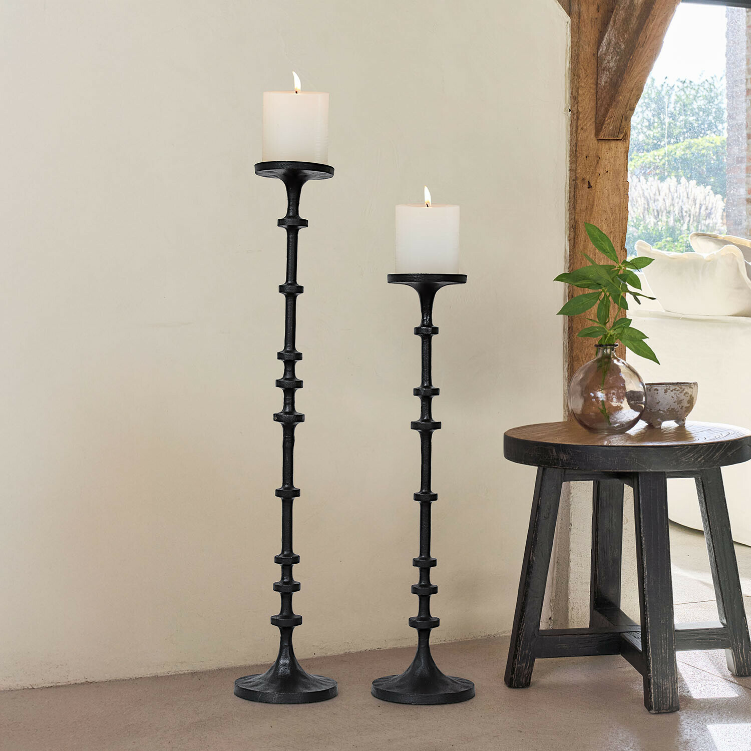 Set van twee zwarte metalen kandelaars met witte kaarsen, natuurlijke interieurdecoratie met licht