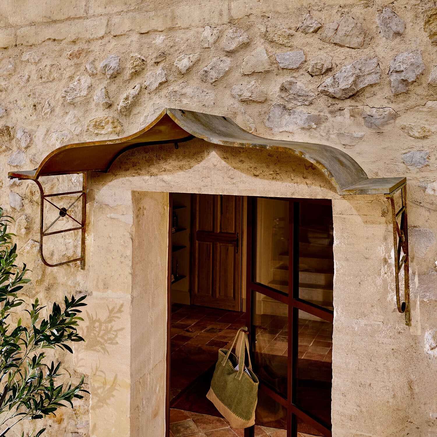 Rustieke metalen luifel boven ingang met stenen muur, bescherming tegen regen