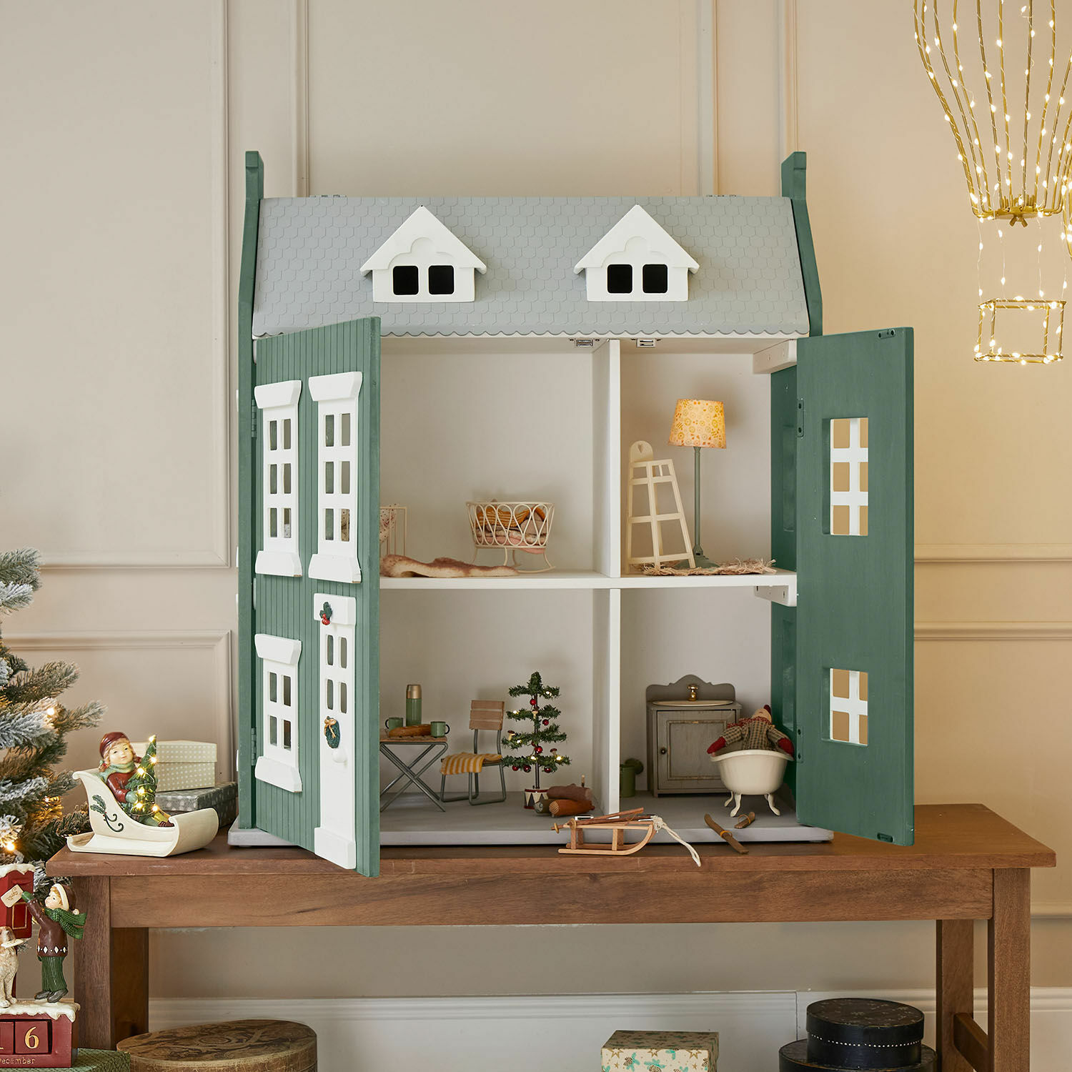 Poppenhuis Avenari Houten poppenhuis in groen-witte kleuren met meubels en kerstdecoratie op houten tafel