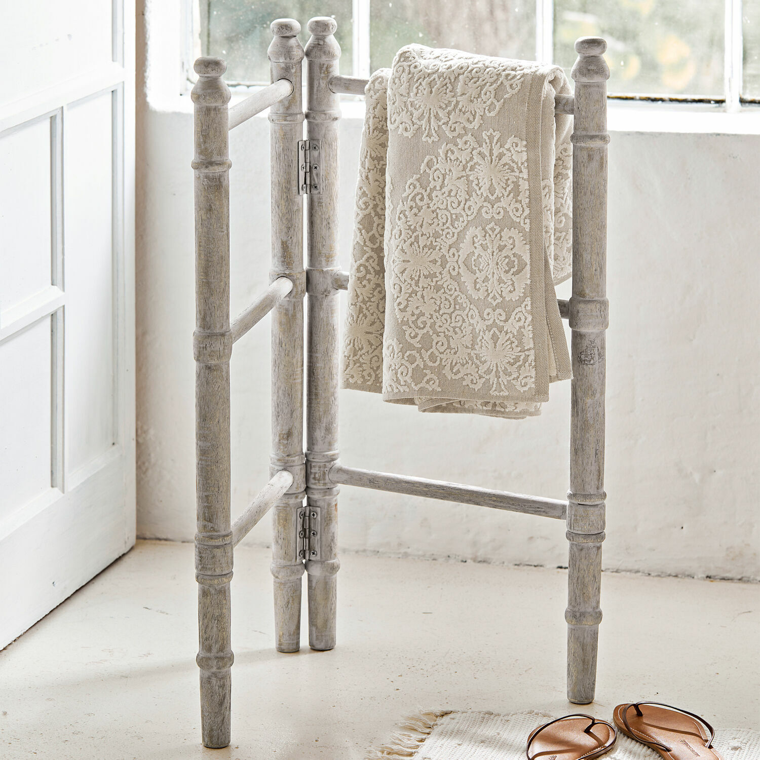 Handdoekhouder Cumana Witte houten handdoekhouder met beige handdoek met patroon in lichte kamer