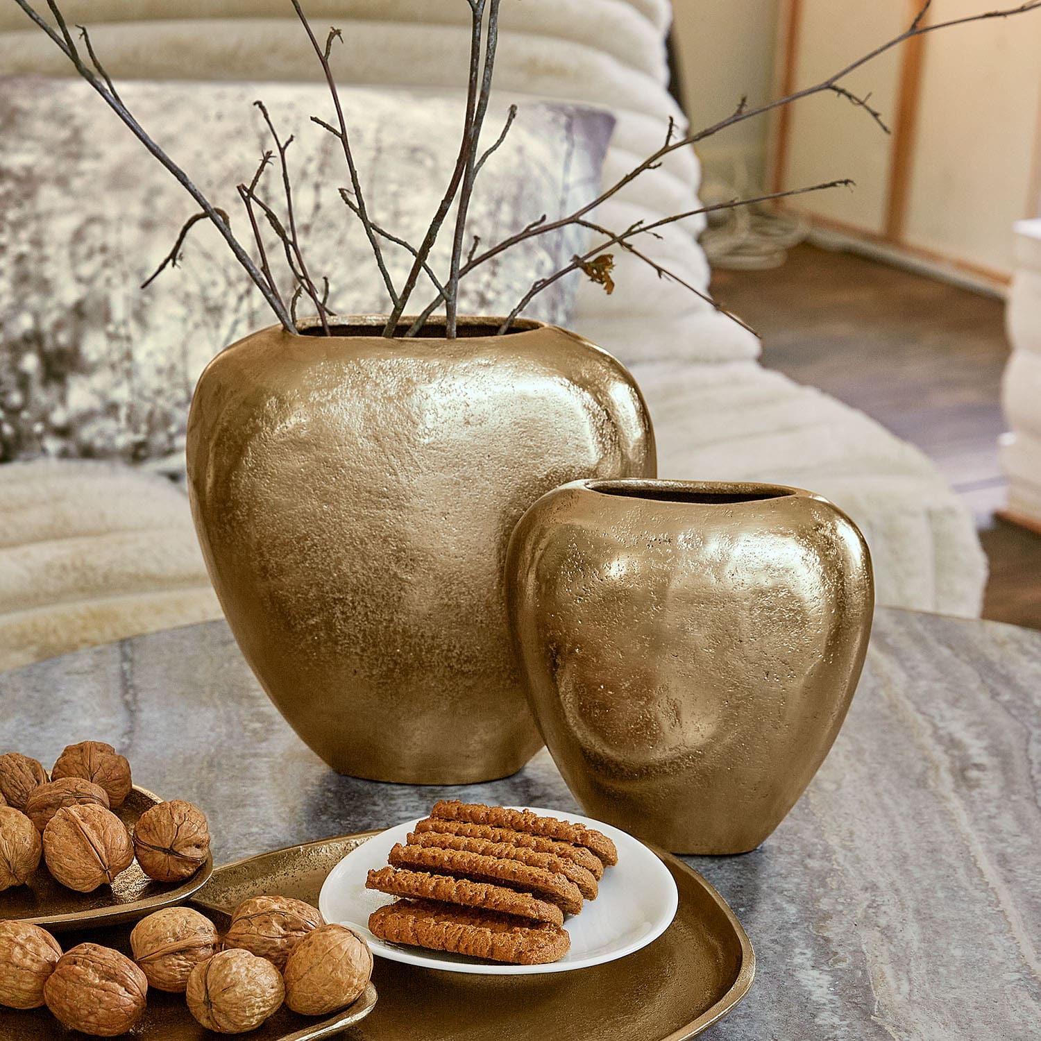 Set van twee gouden keramische vazen op tafel met walnoten en koekjes, interieurdecoratie