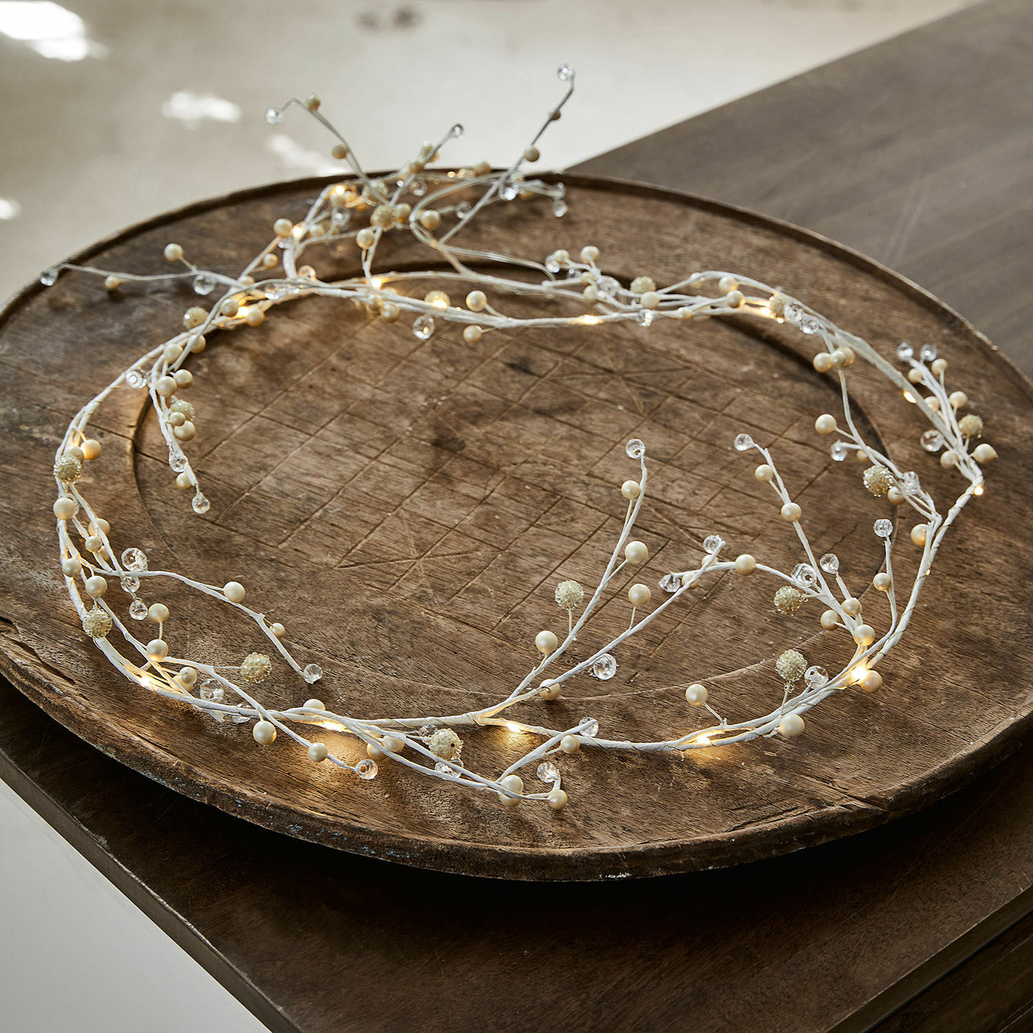 Fijne witte LED-decoratiekrans met parels op houten schaal, sfeervolle feestverlichting