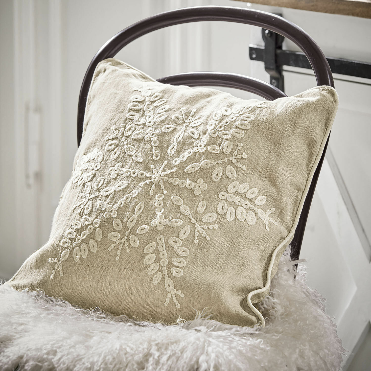 Kussenhoes Snowflake Beige linnen kussen met witte borduur op stoel met bontbekleding, interieurdecoratie