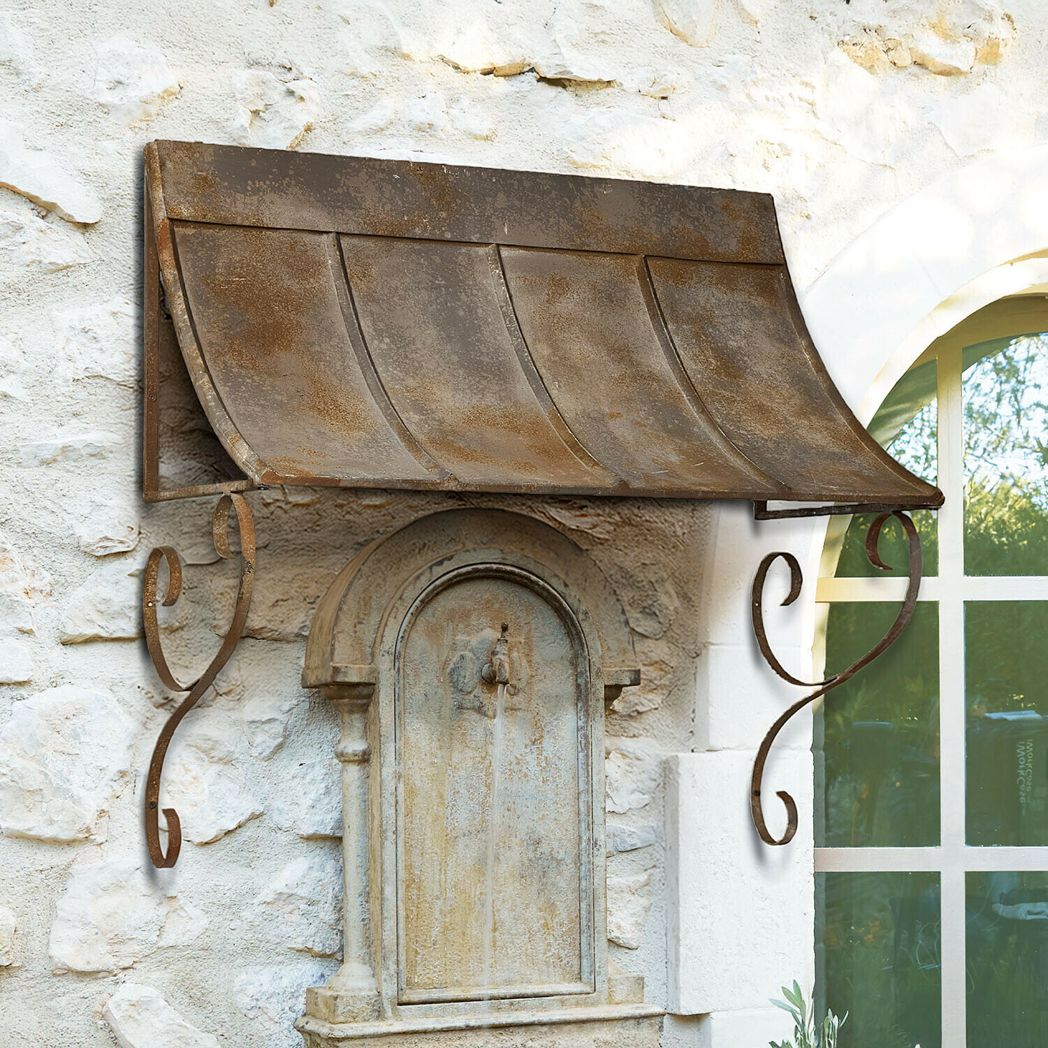 Rustieke metalen luifel met roestkleur boven een stenen buitenfontein