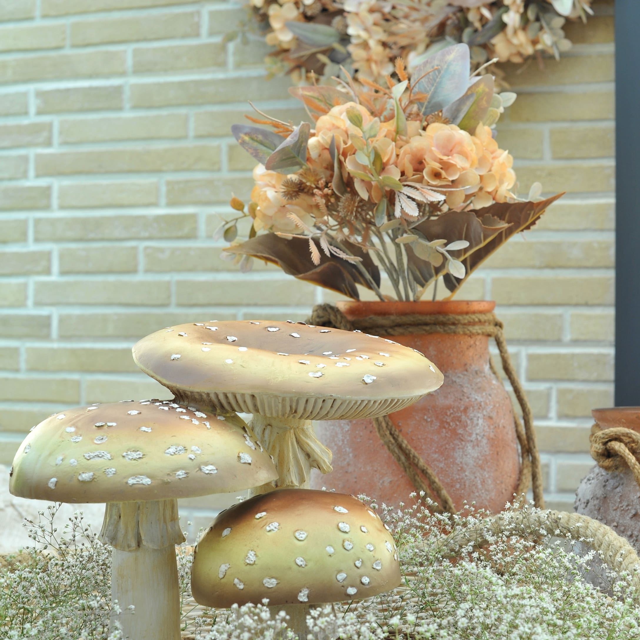 Decoratieve bruin-beige paddenstoelen met herfstboeket op achtergrond tegen bakstenen muur