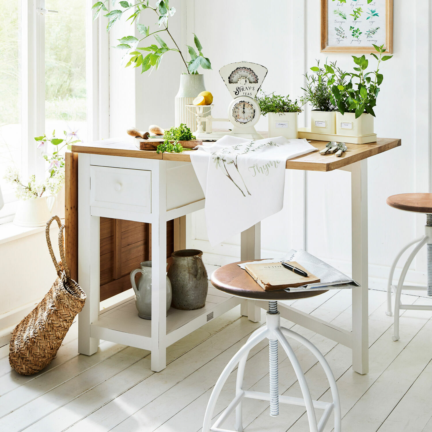 Witte houten keukentafel met licht houten blad en groene planten in potten