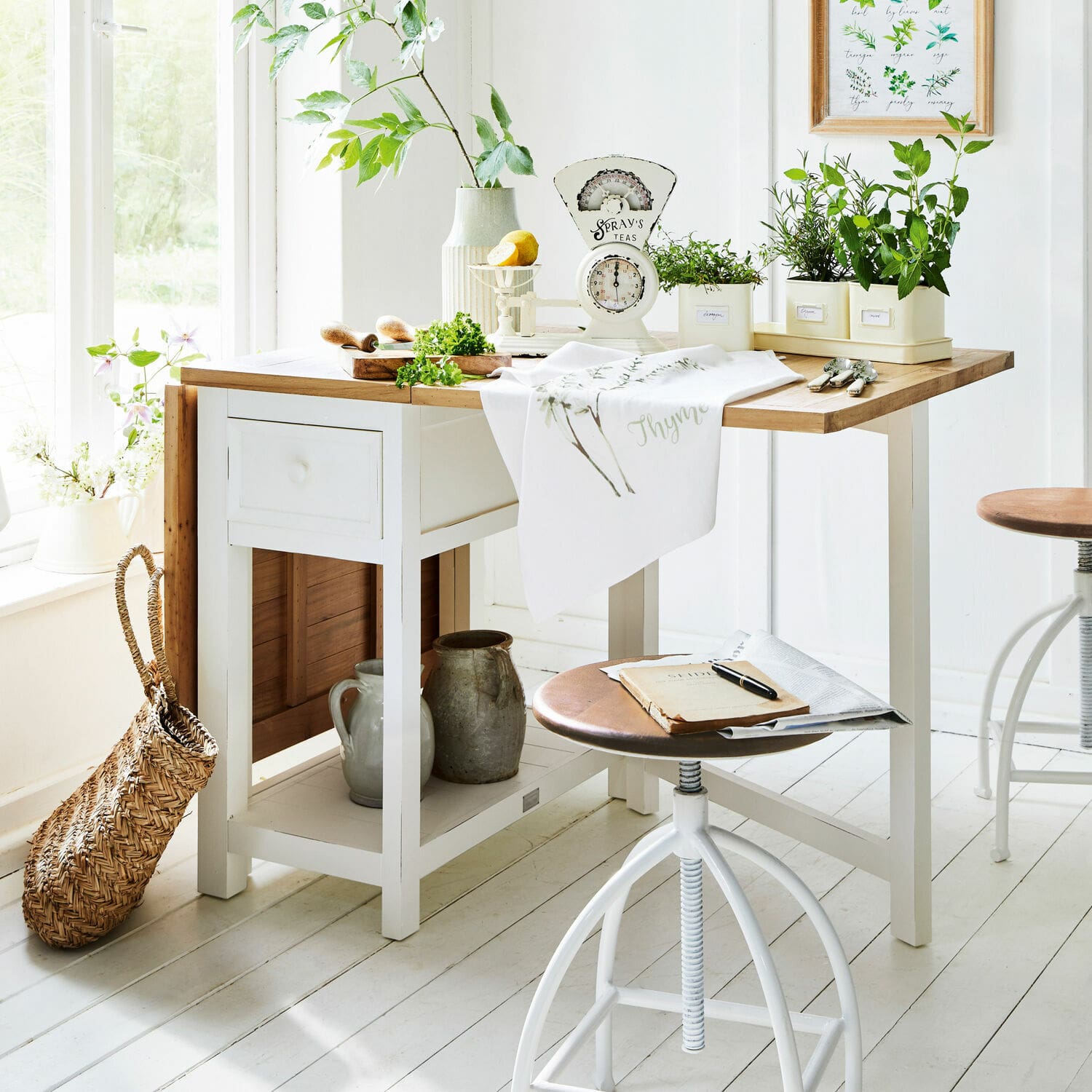 Tafel Dale Witte houten keukentafel met licht houten blad en groene planten in potten