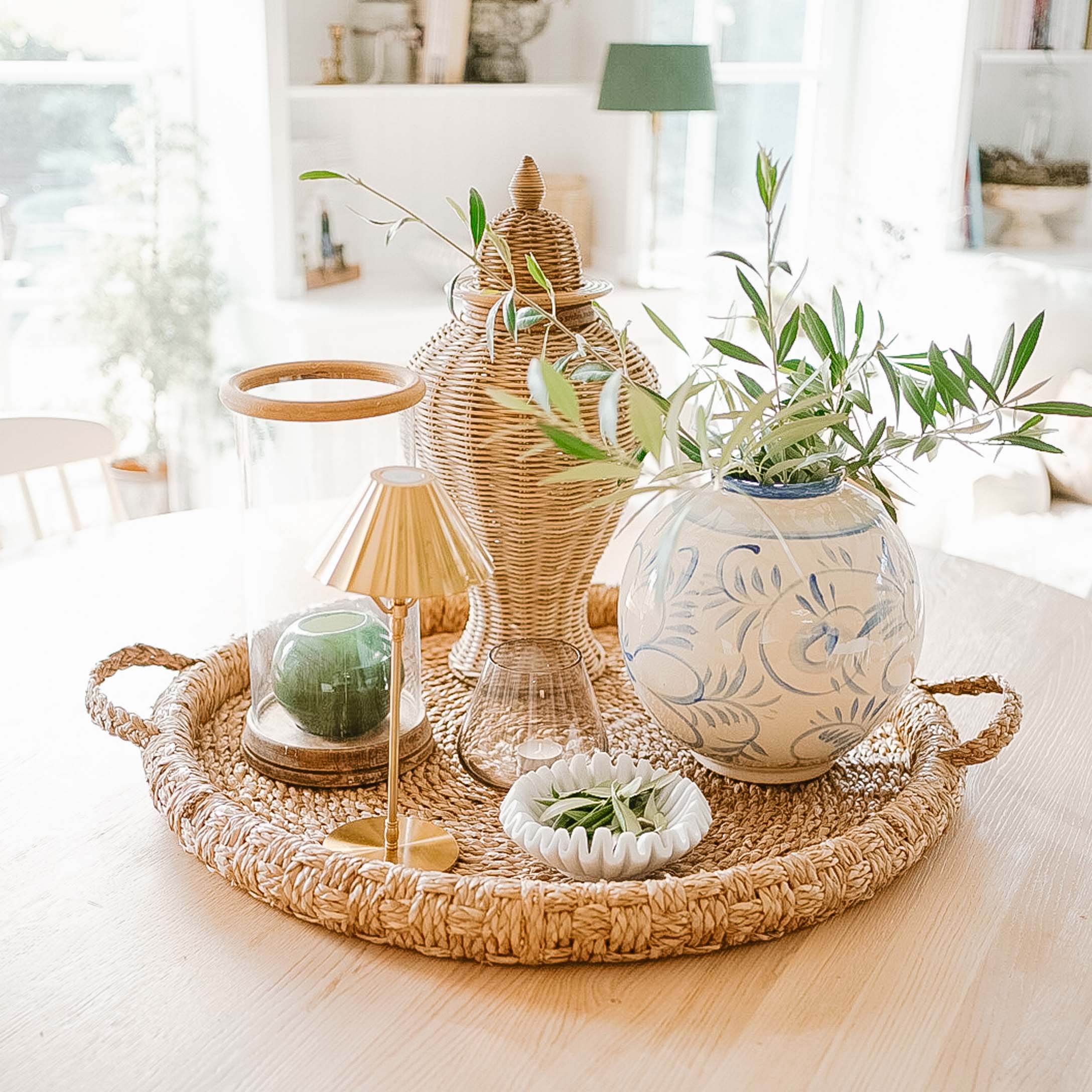 Rieten dienblad met keramische vaas en groene takken voor natuurlijke interieurdecoratie