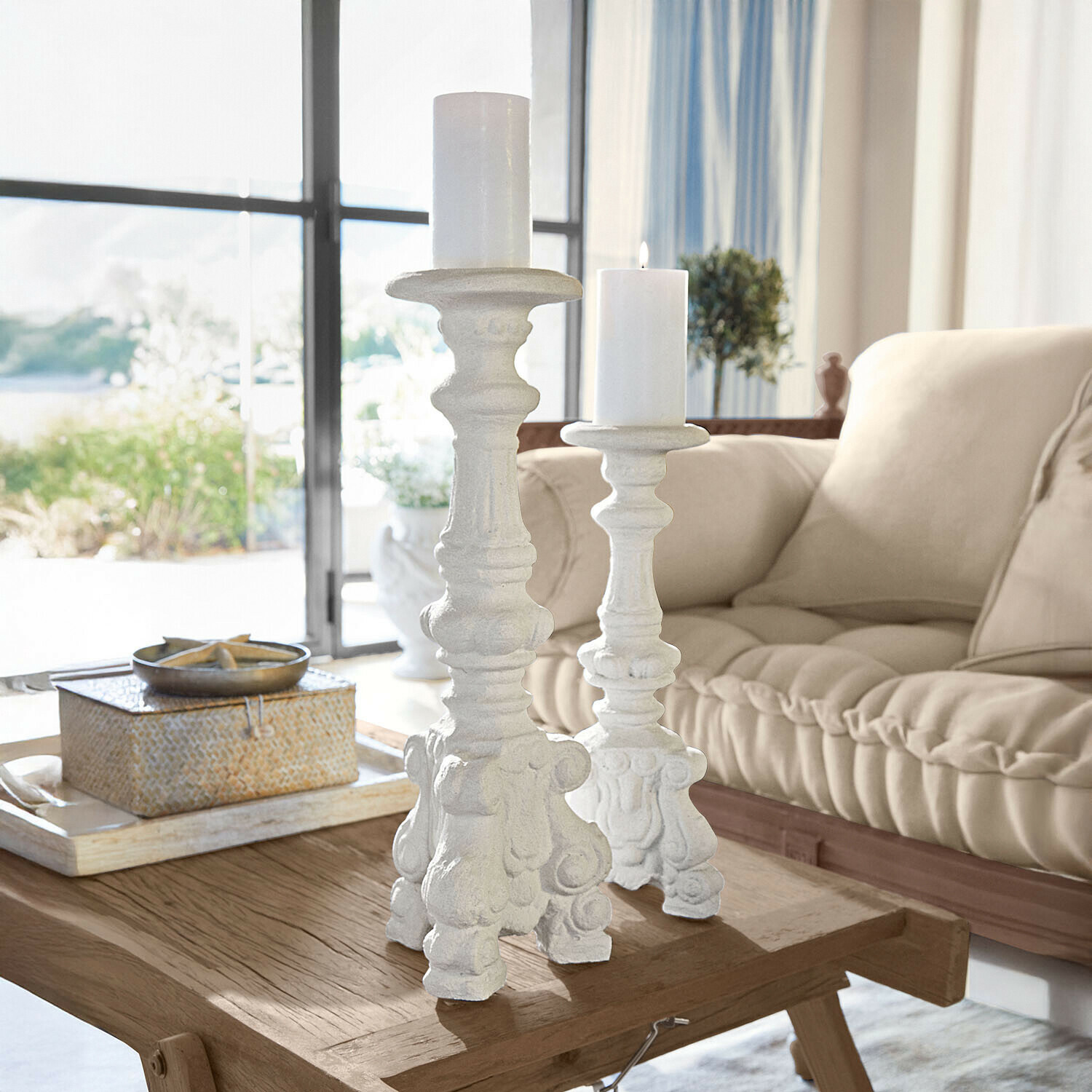 Witte decoratieve kandelaars met versierd patroon op houten tafel in lichte woonkamer