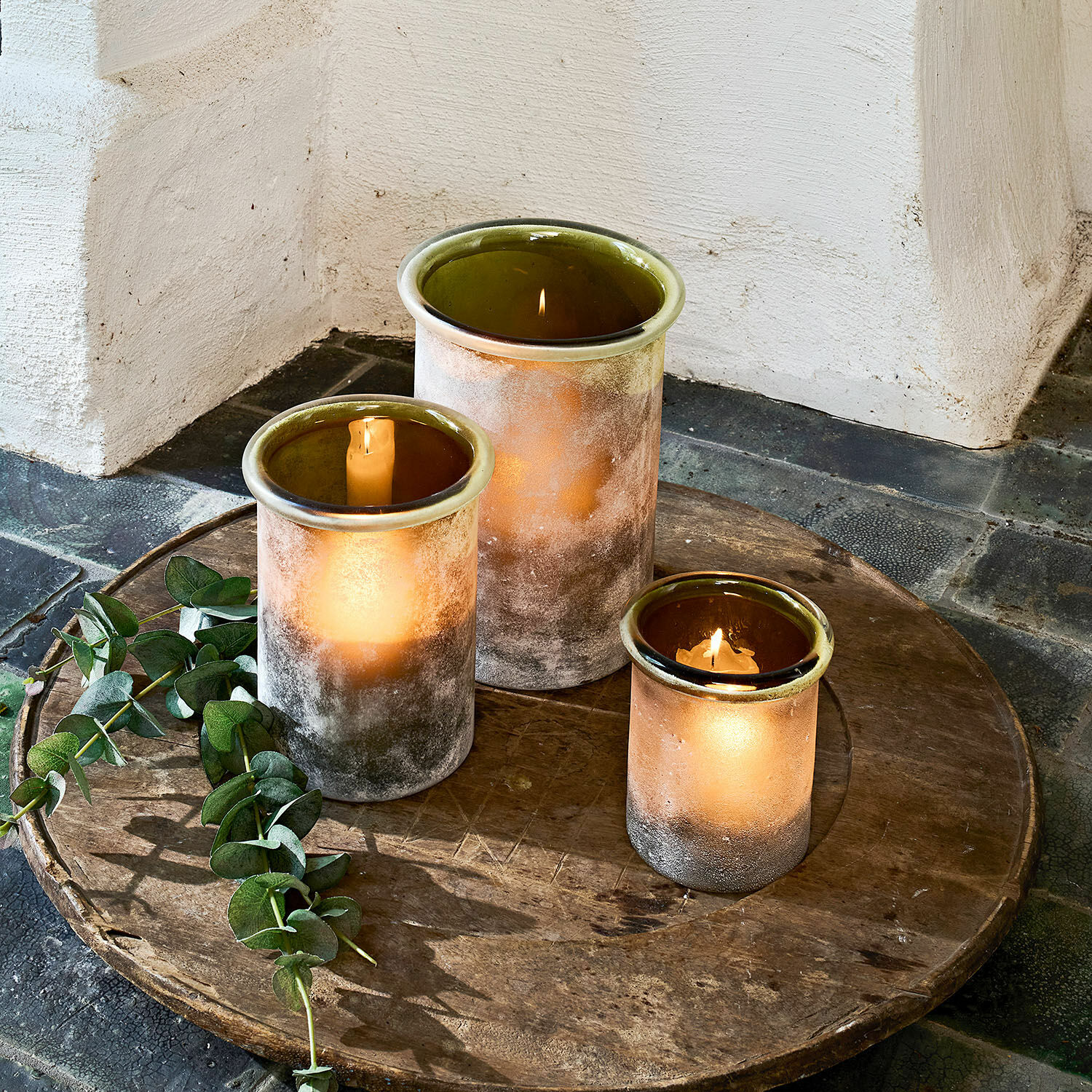 Windlicht set van 3 Iskira Set van drie matte glazen windlichten in bruin- en groentinten op een houten dienblad