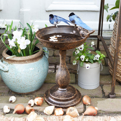 Decoratieve metalen schaal op voet met blauwe vogelbeelden, tuin- en woondecoratie
