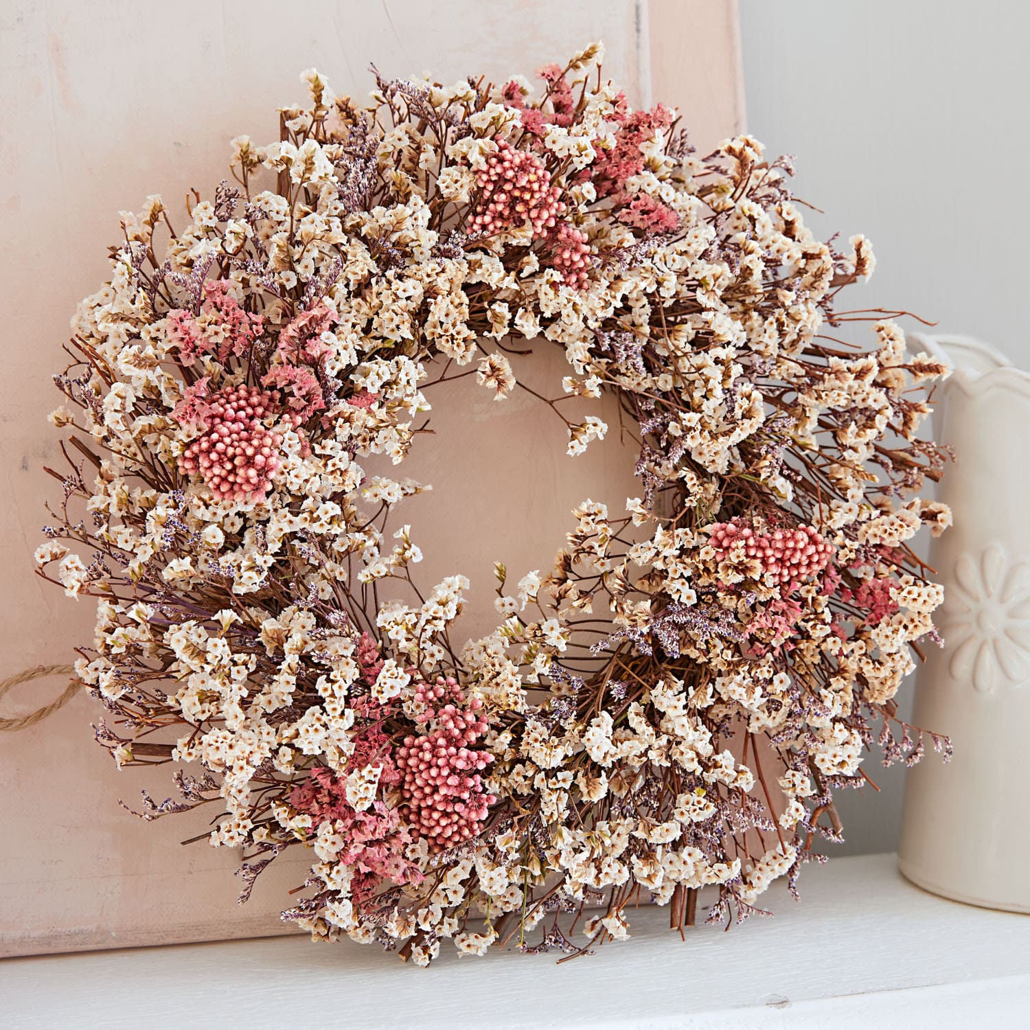 Krans van gedroogde bloemen in crème en roze tinten voor natuurlijke woondecoratie