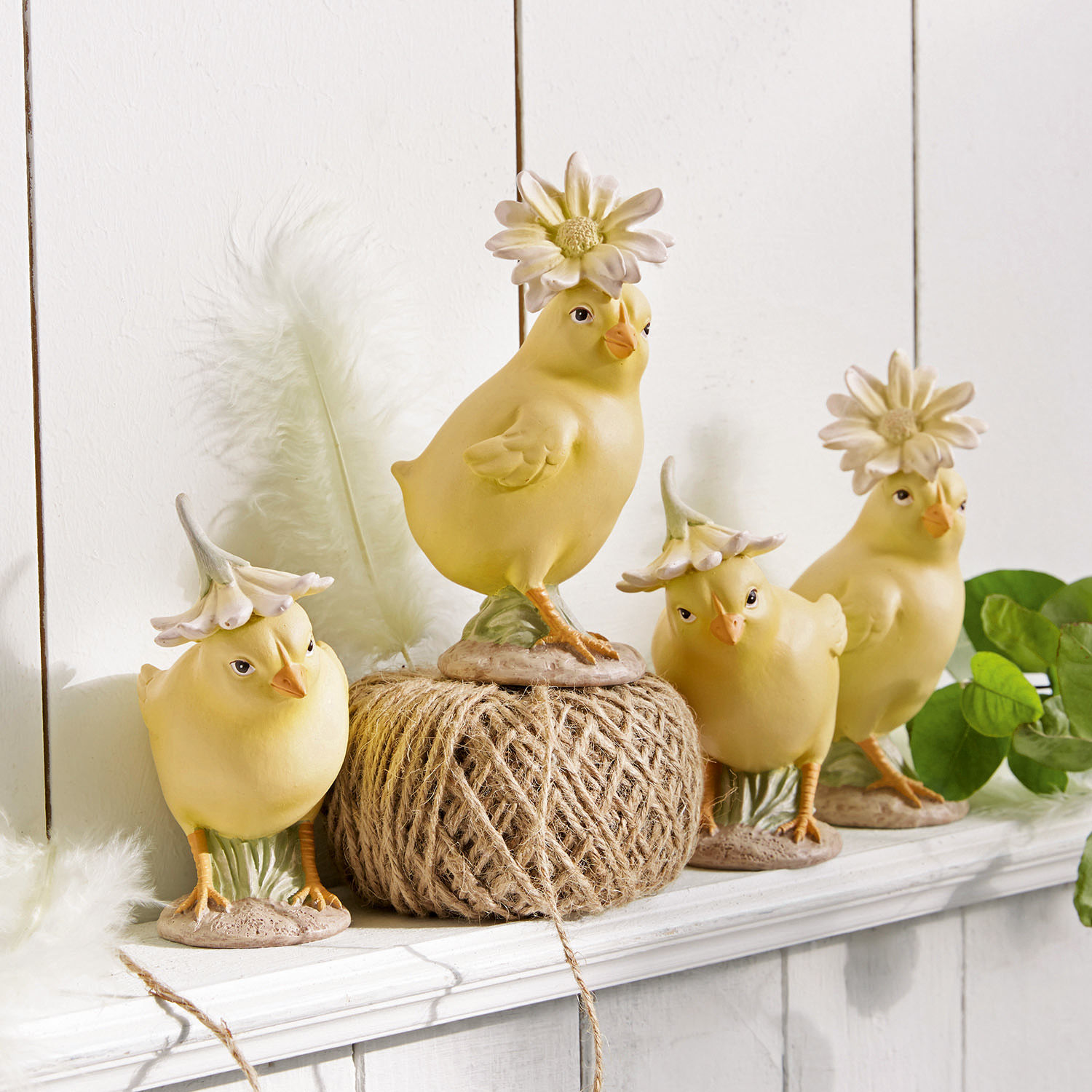 Kuiken set van 4 Garsonne Vier gele keramische kuikenfiguren met bloemenhoedjes op een witte decoratieve plank