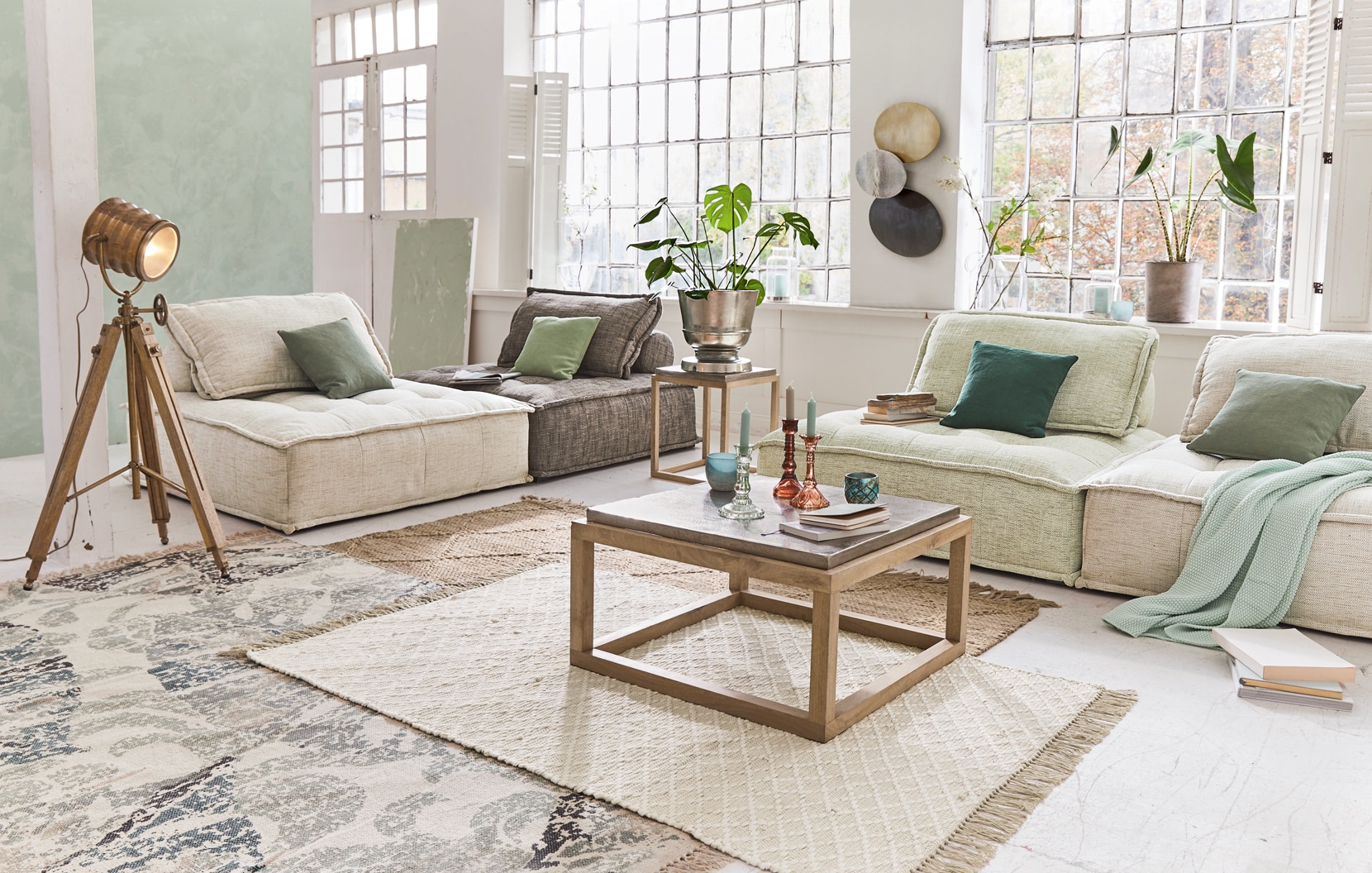 Gezellige woonkamer met beige en grijze banken, houten salontafel en loft-statieflamp