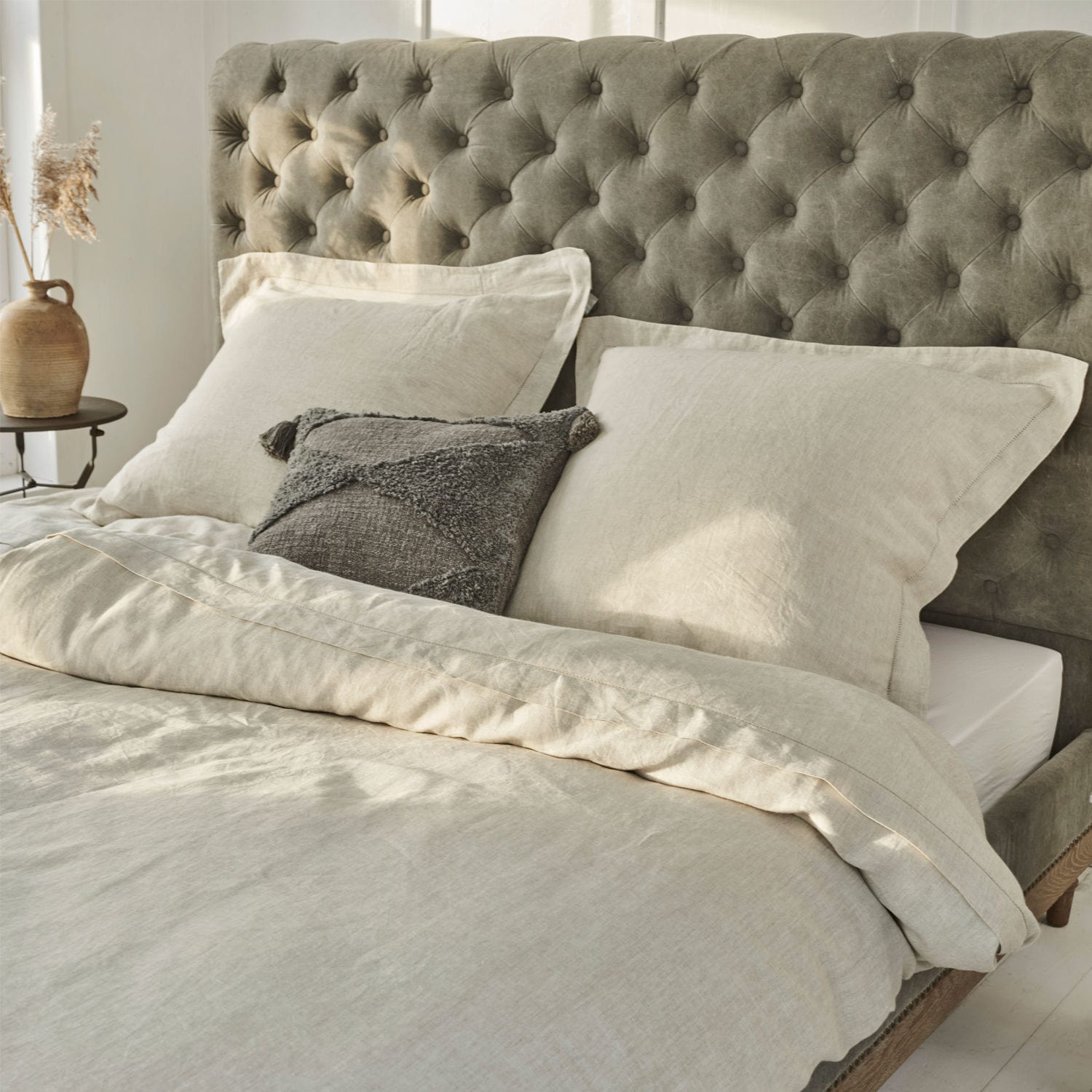 Beddengoed Kilanema Beige linnen beddengoed op bed met grijs gestoffeerd hoofdeinde, grijs sierkussen